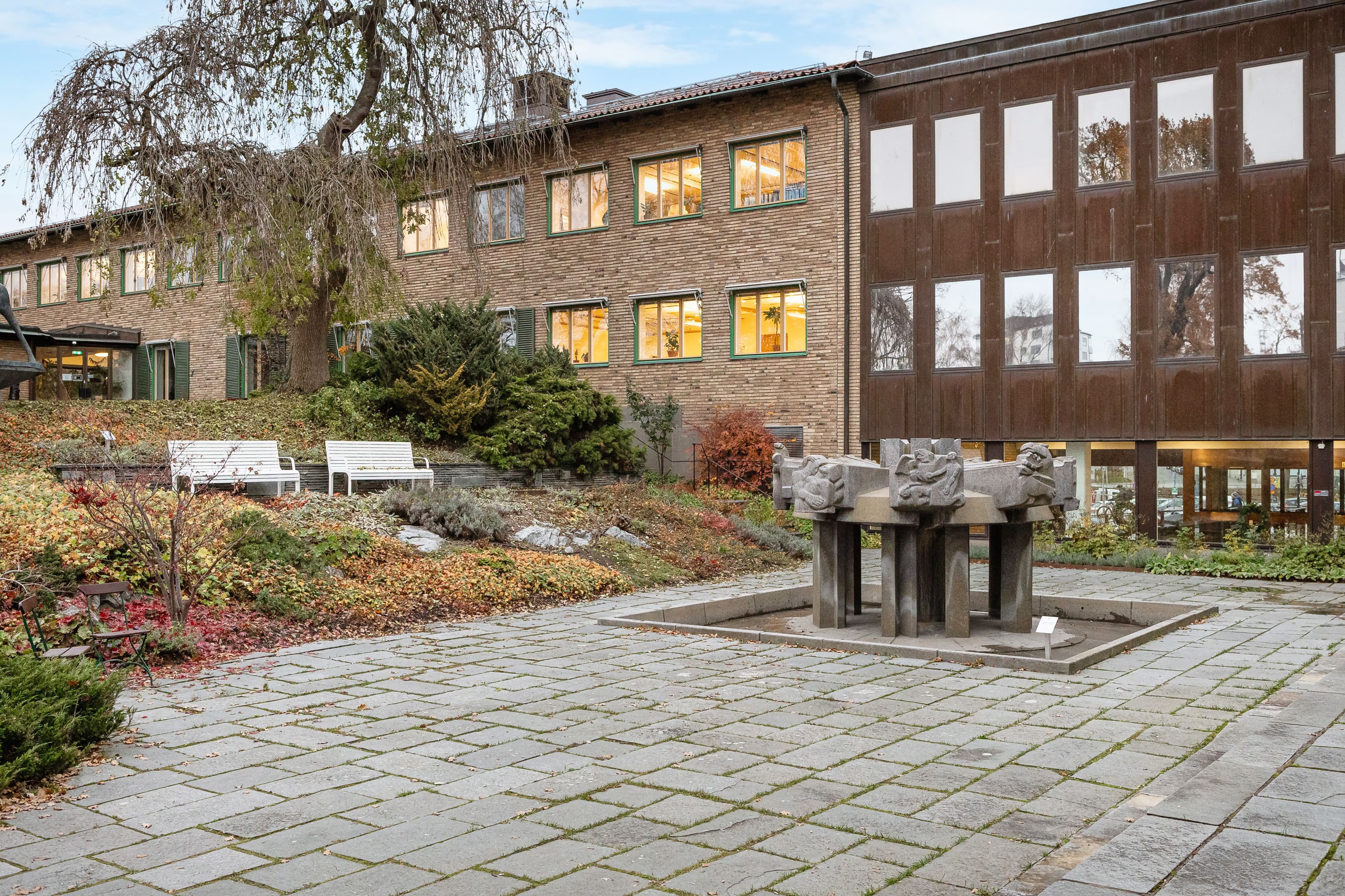 En byggnad med en innergård och en staty framför den.