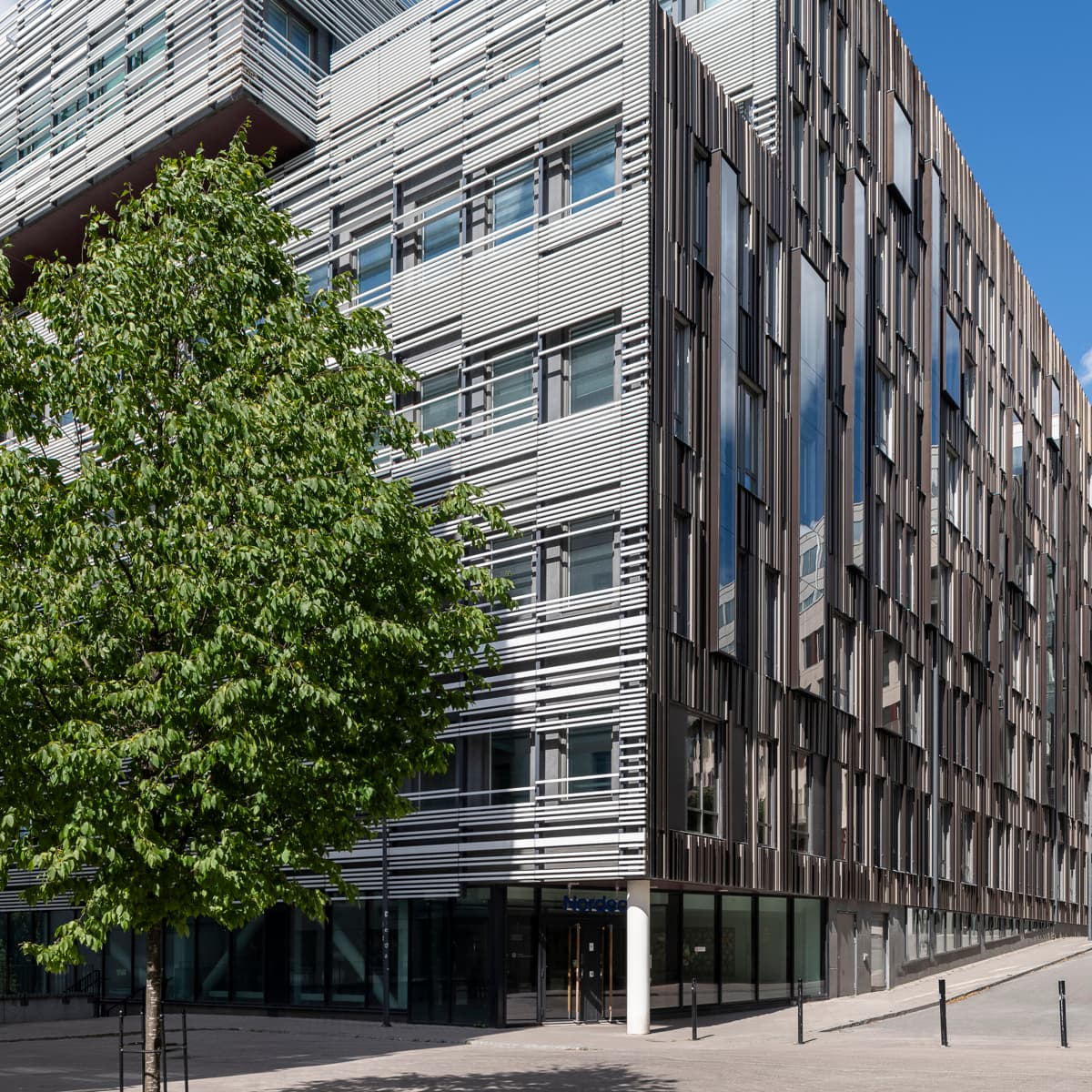 En stor byggnad med ett träd framför sig.