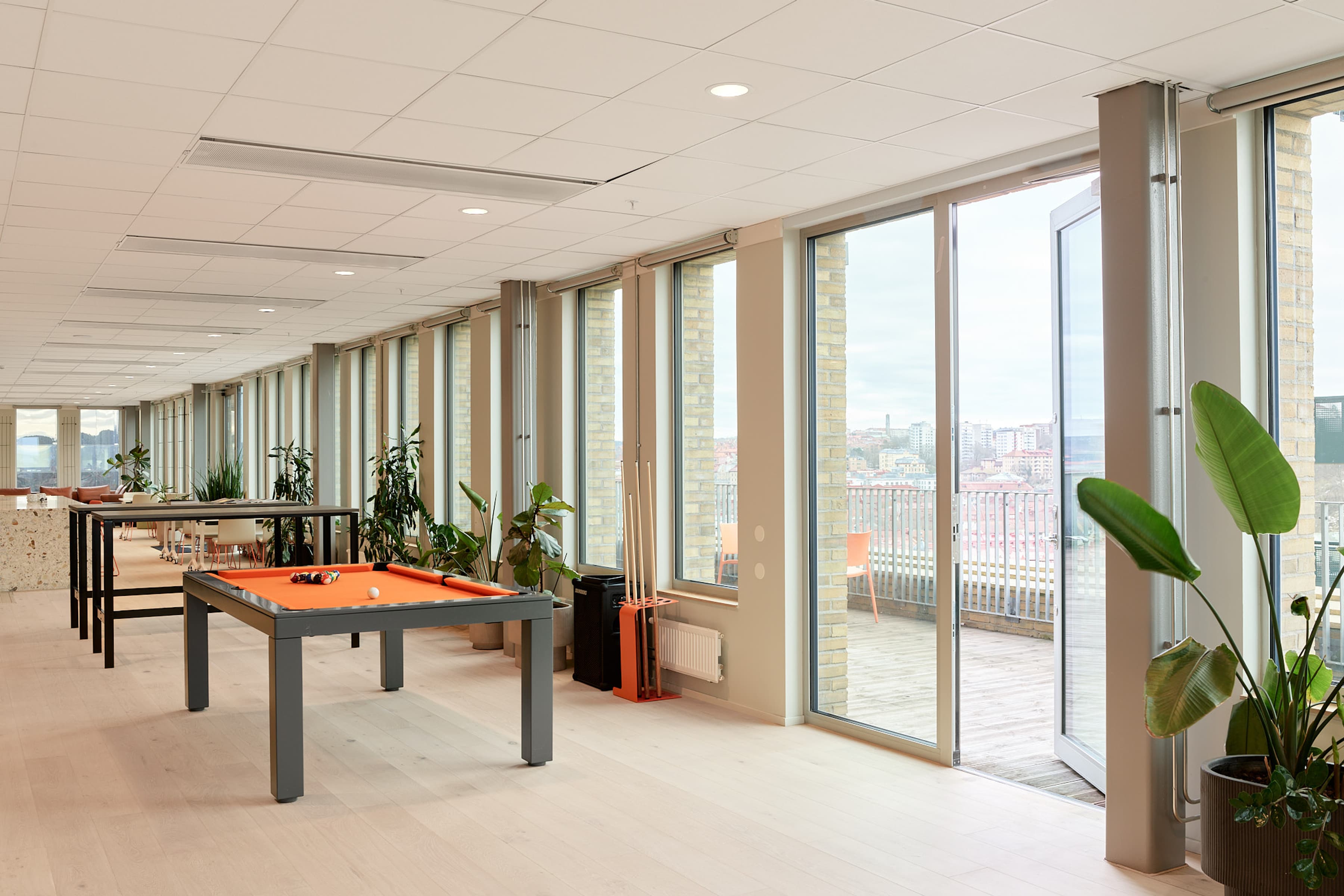 Ett rum med biljardbord och många fönster.