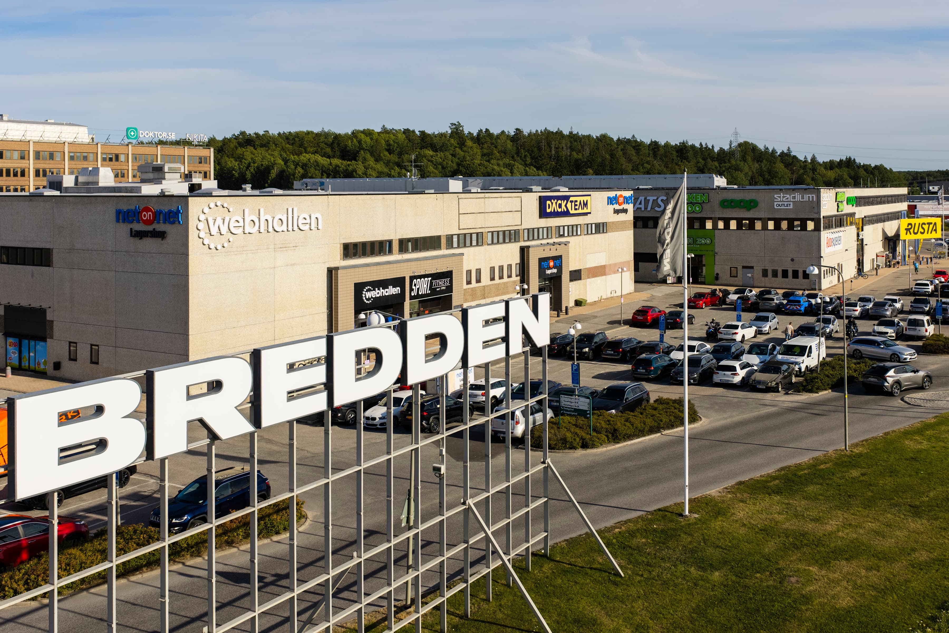 En parkeringsplats full av bilar intill en byggnad.