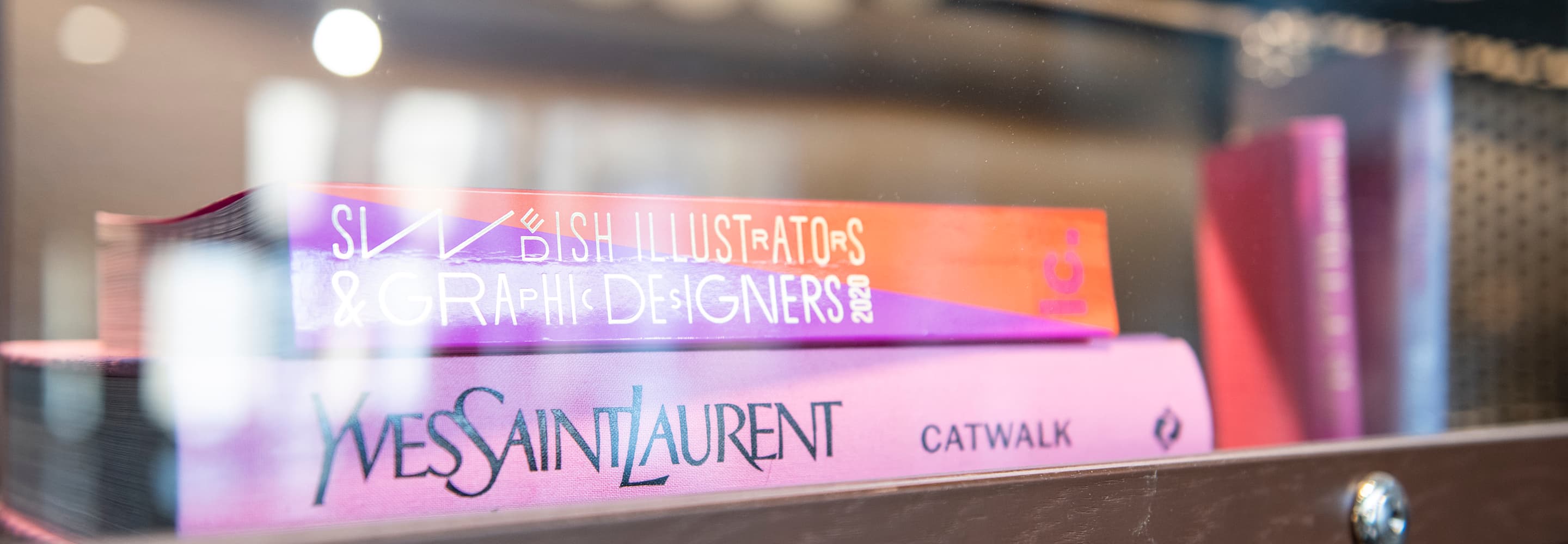 En trave böcker som ligger på en hylla.