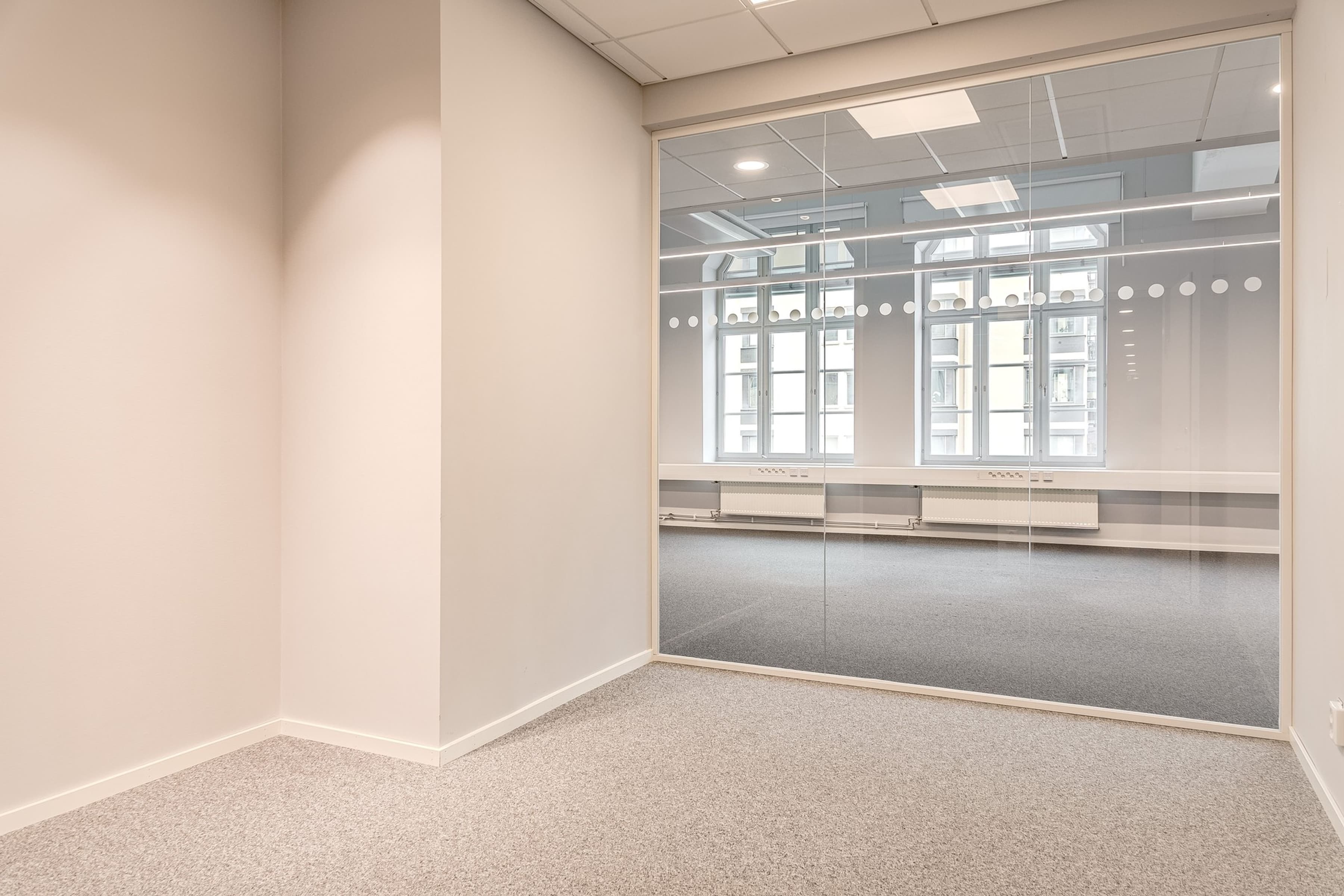 Ett tomt rum med ett stort fönster i.