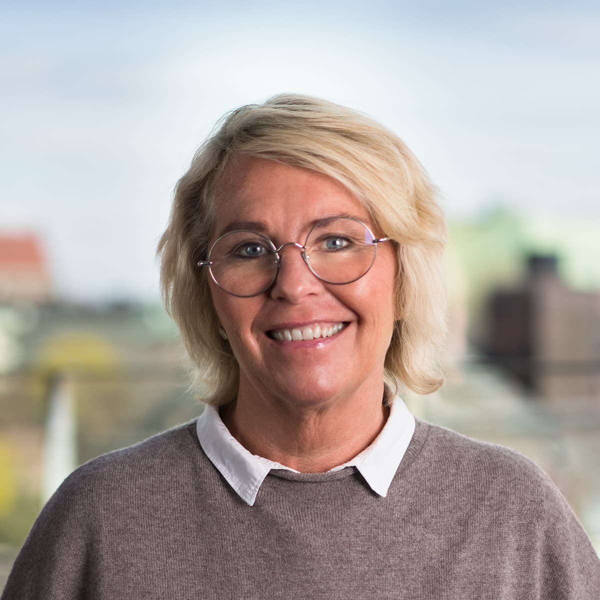 En kvinna som står framför ett fönster.