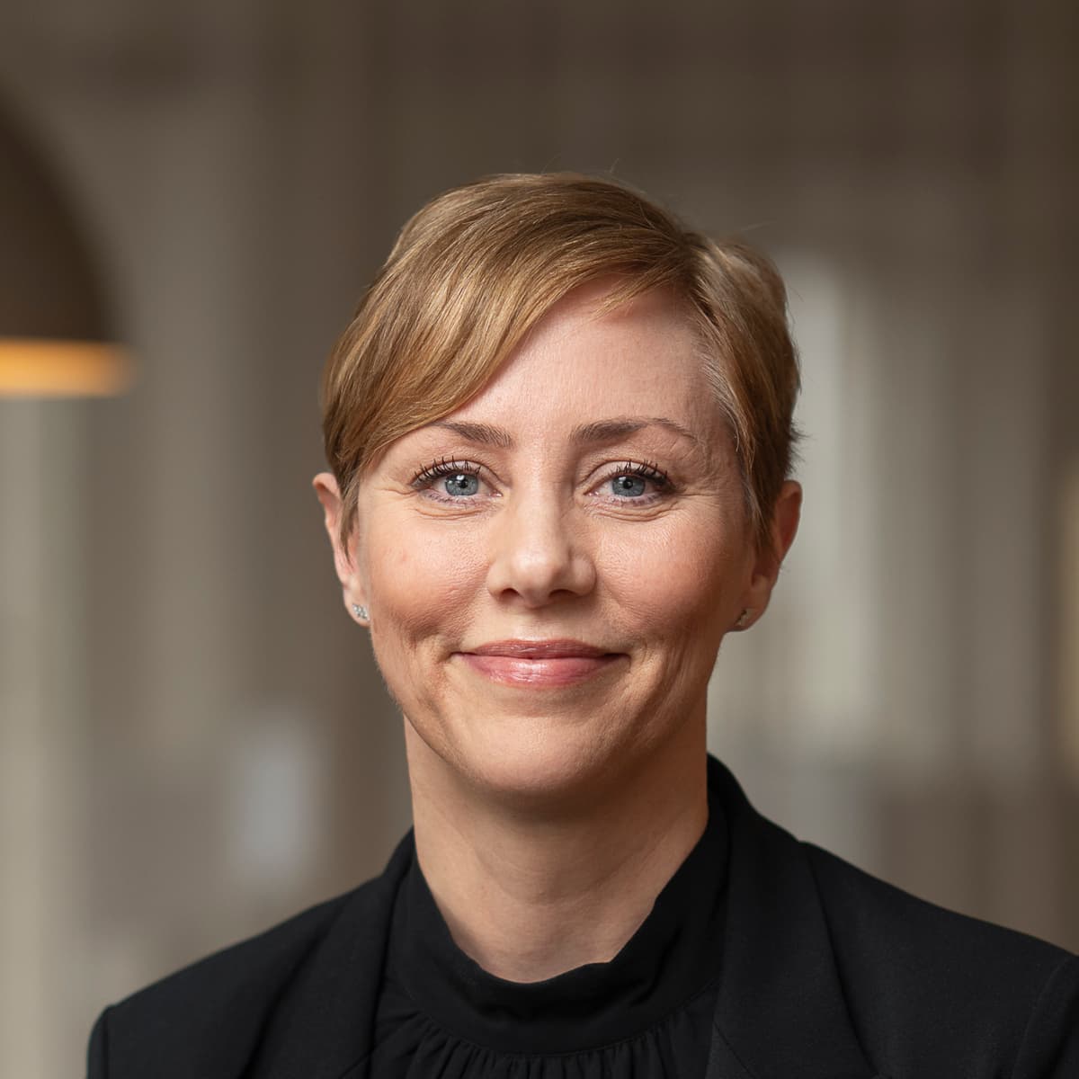 En kvinna står framför ett bord i ett rum.