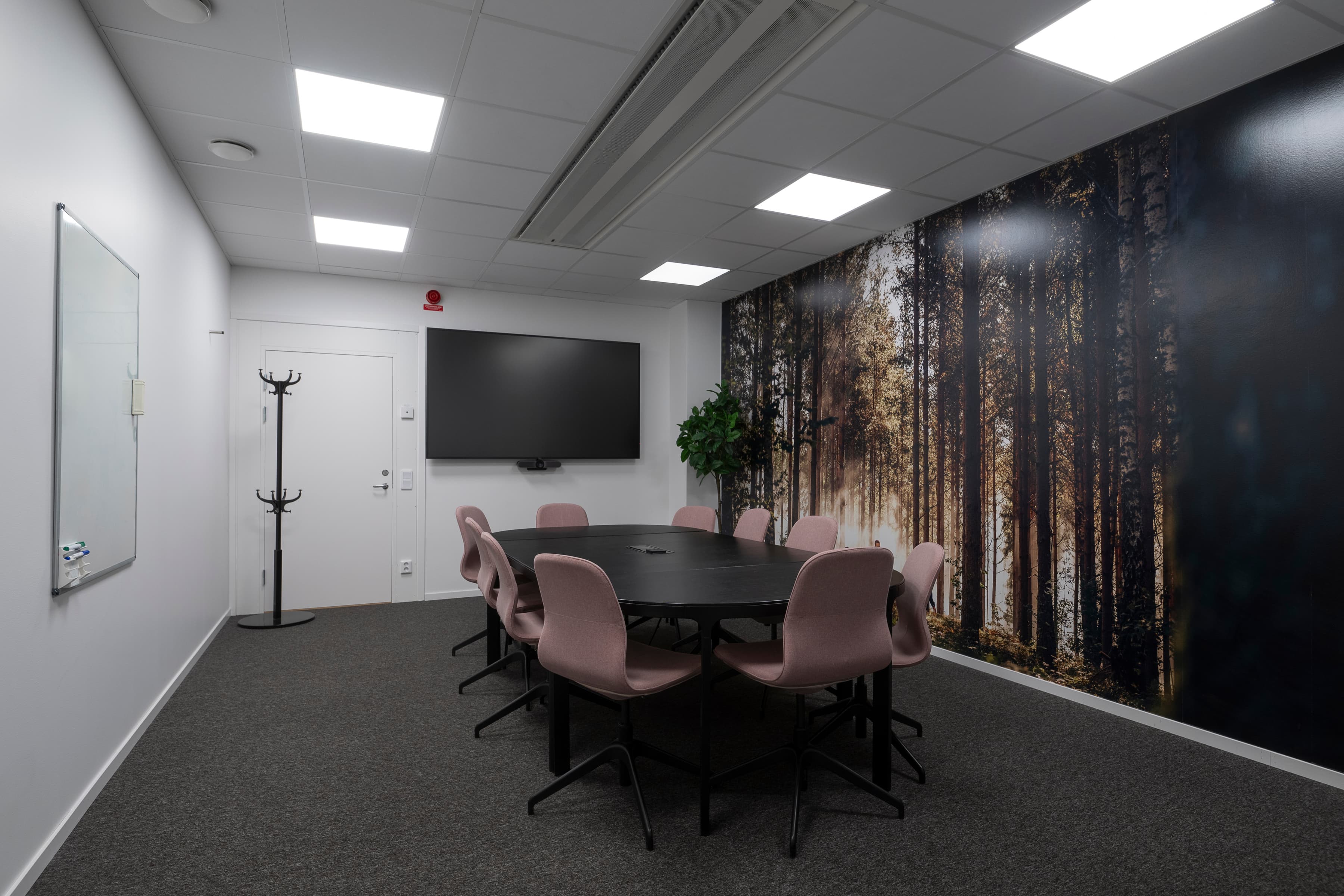 Ett konferensrum med ett bord och stolar.