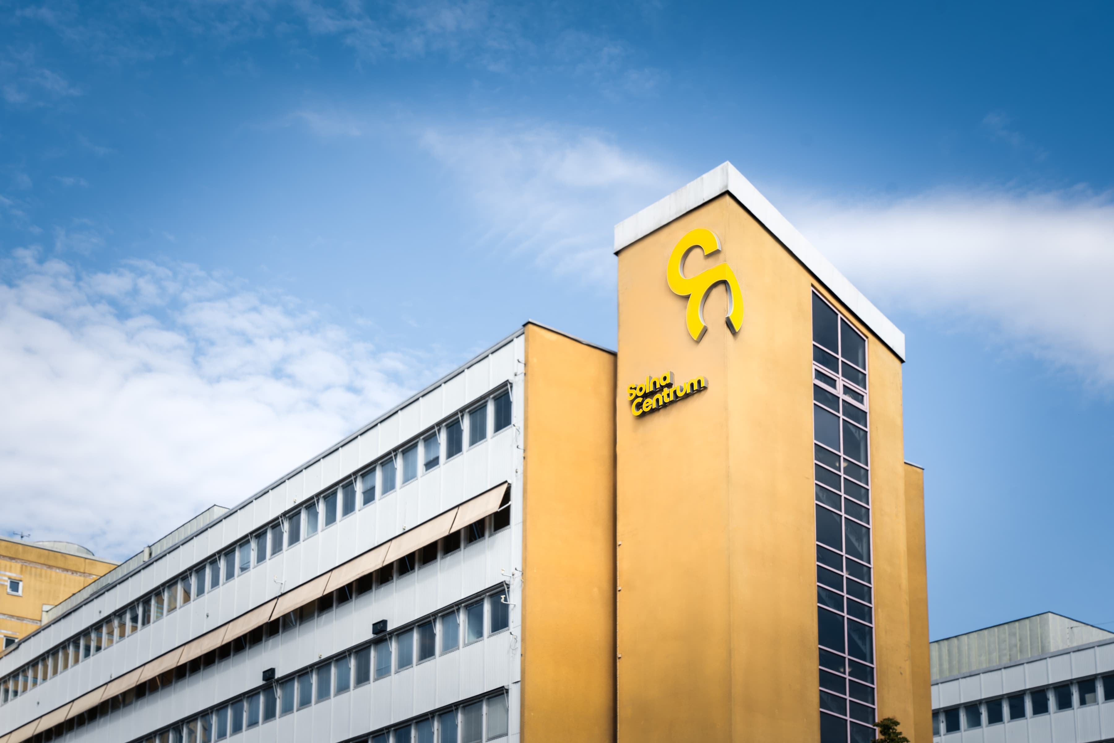 En stor byggnad med en gul och svart logotyp på.