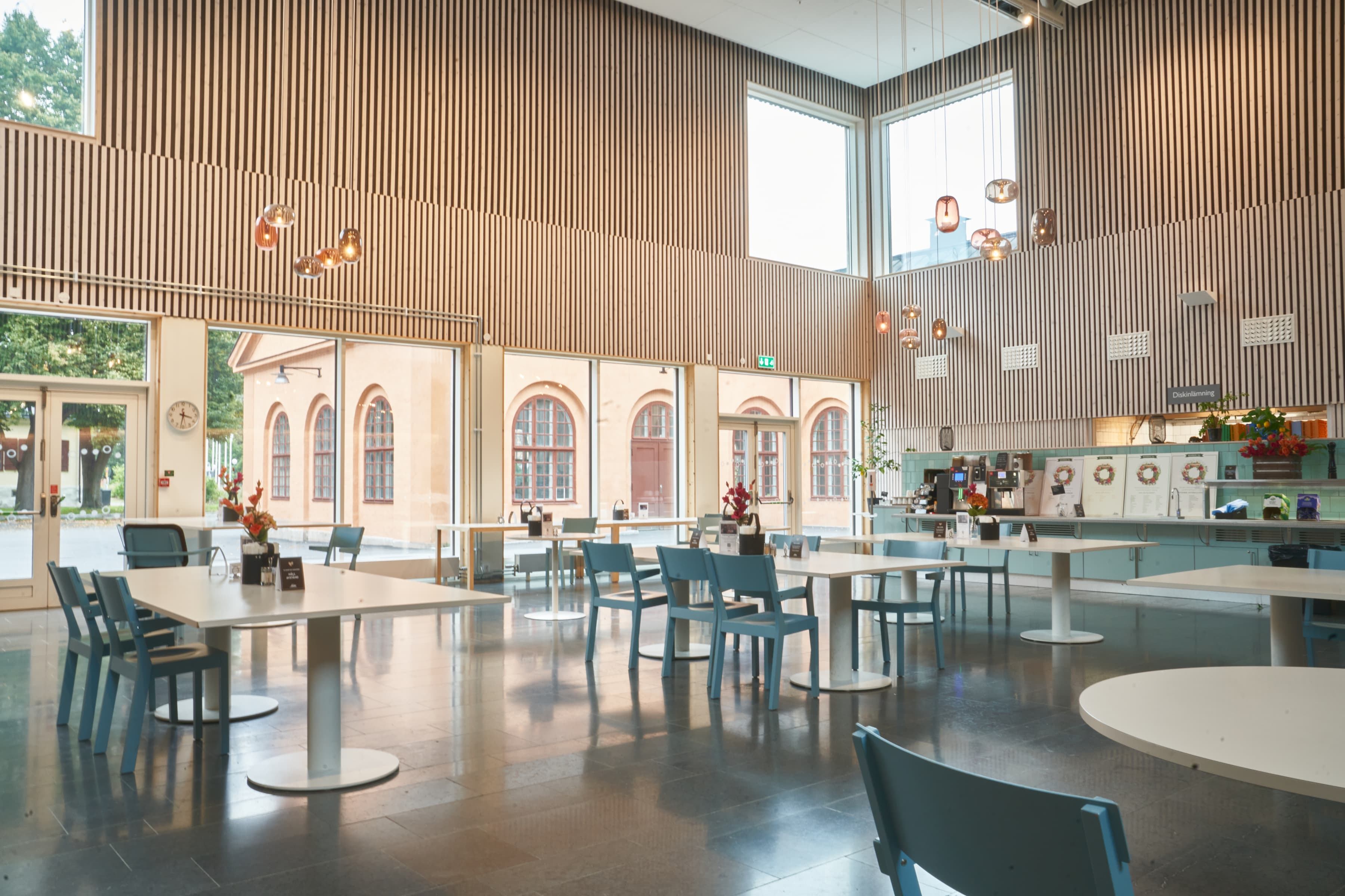 Ett stort rum med bord och stolar inuti.