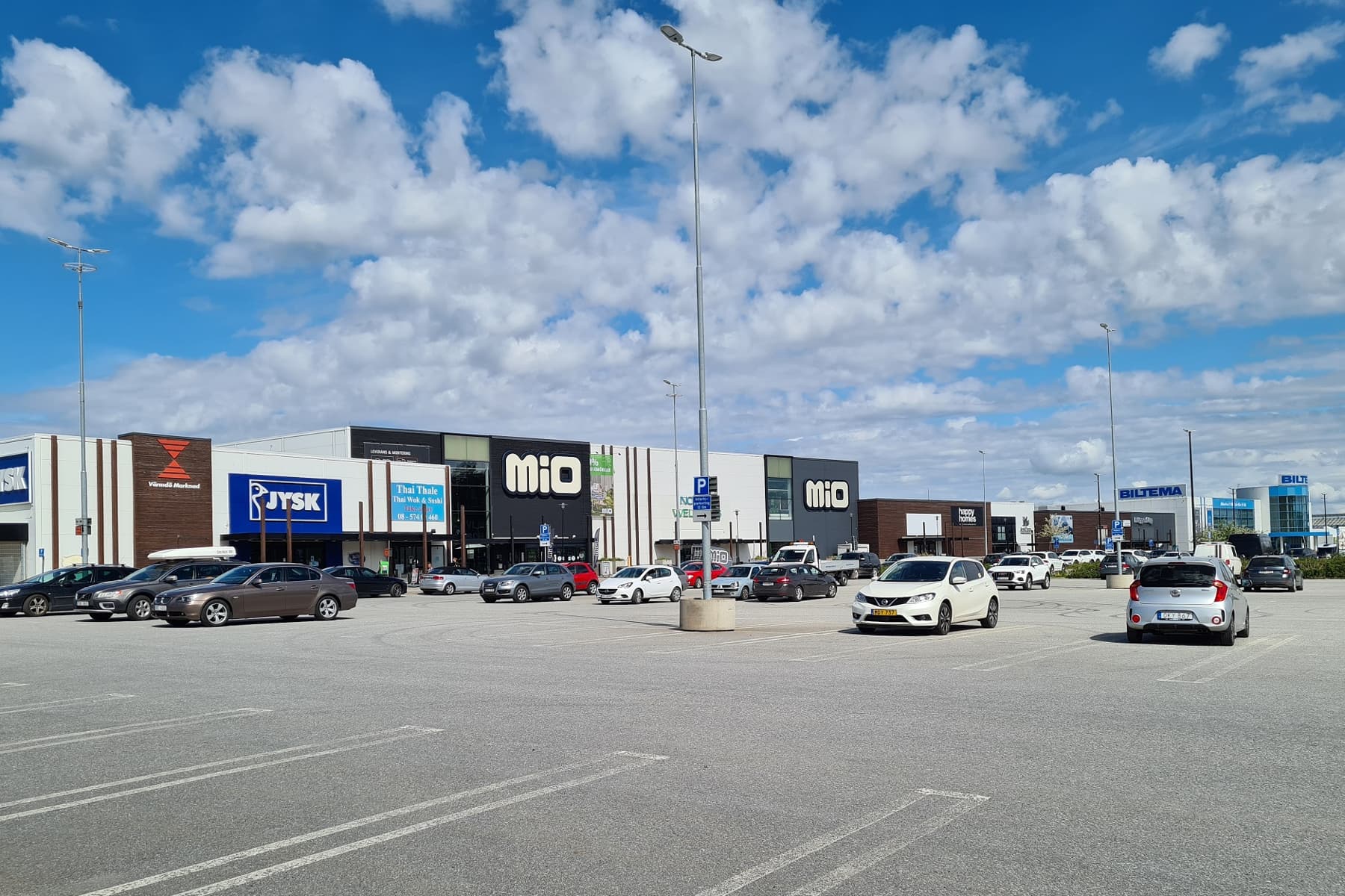 En parkeringsplats fylld med massor av parkerade bilar.