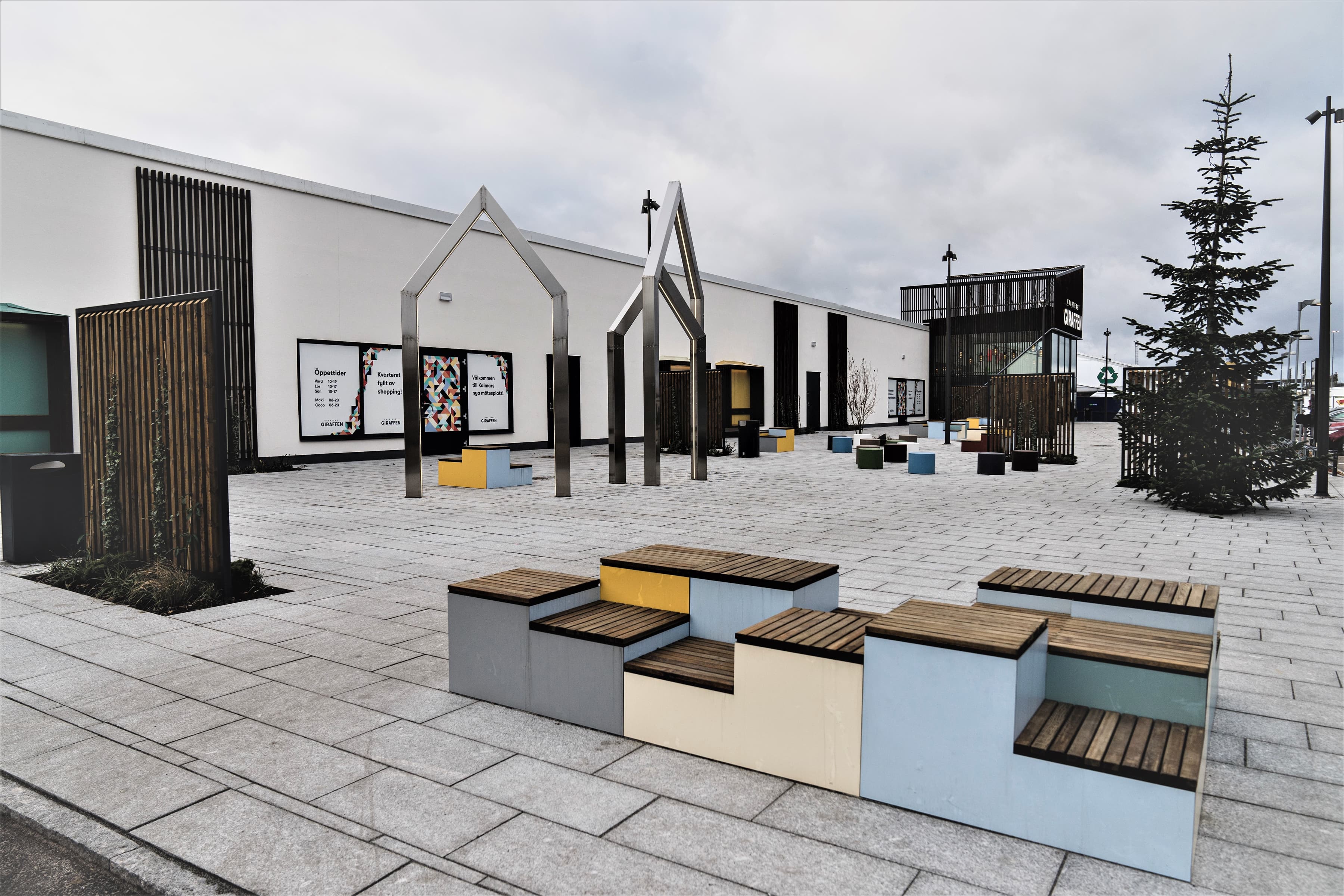 En grupp bänkar som sitter framför en byggnad.