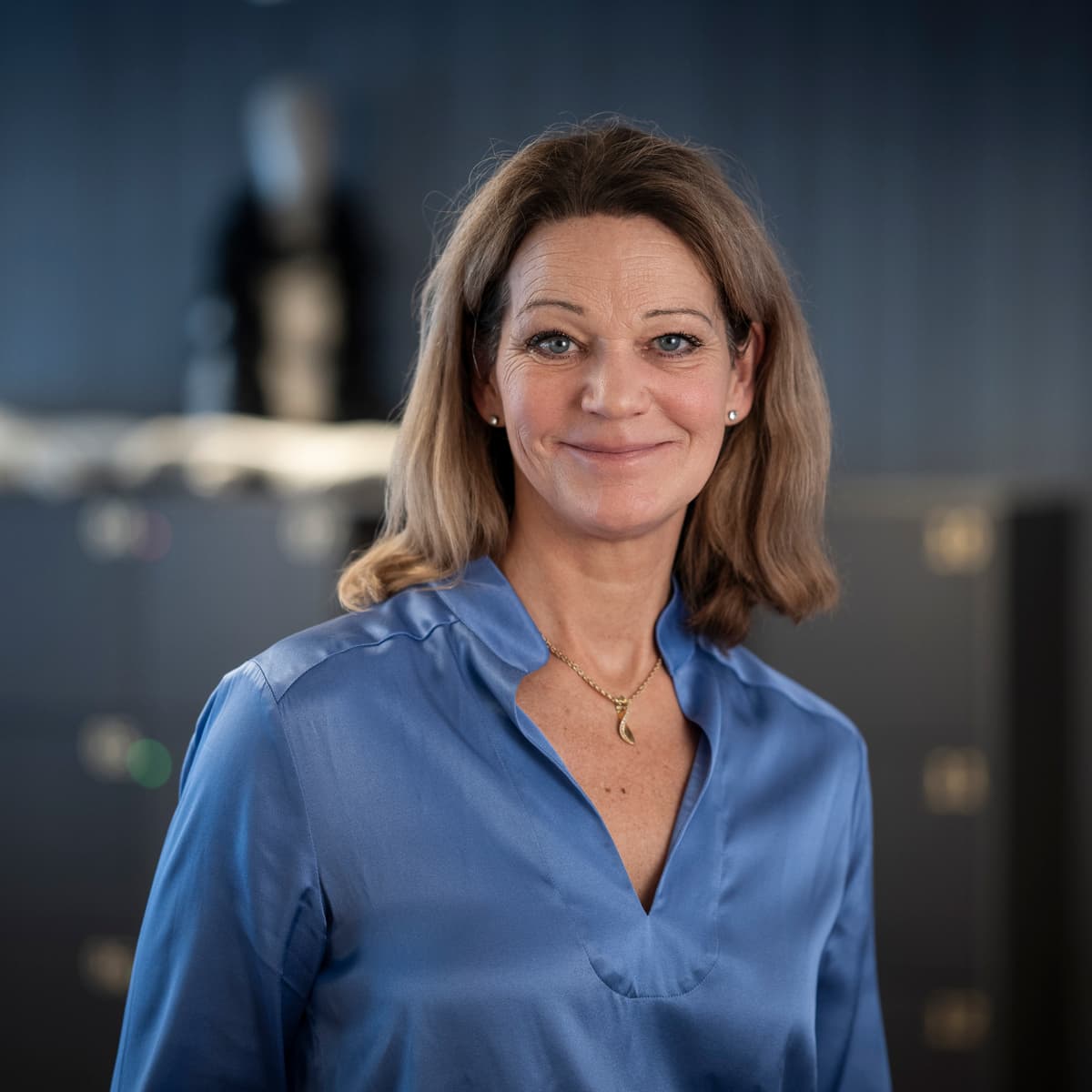 En kvinna står framför ett kylskåp.