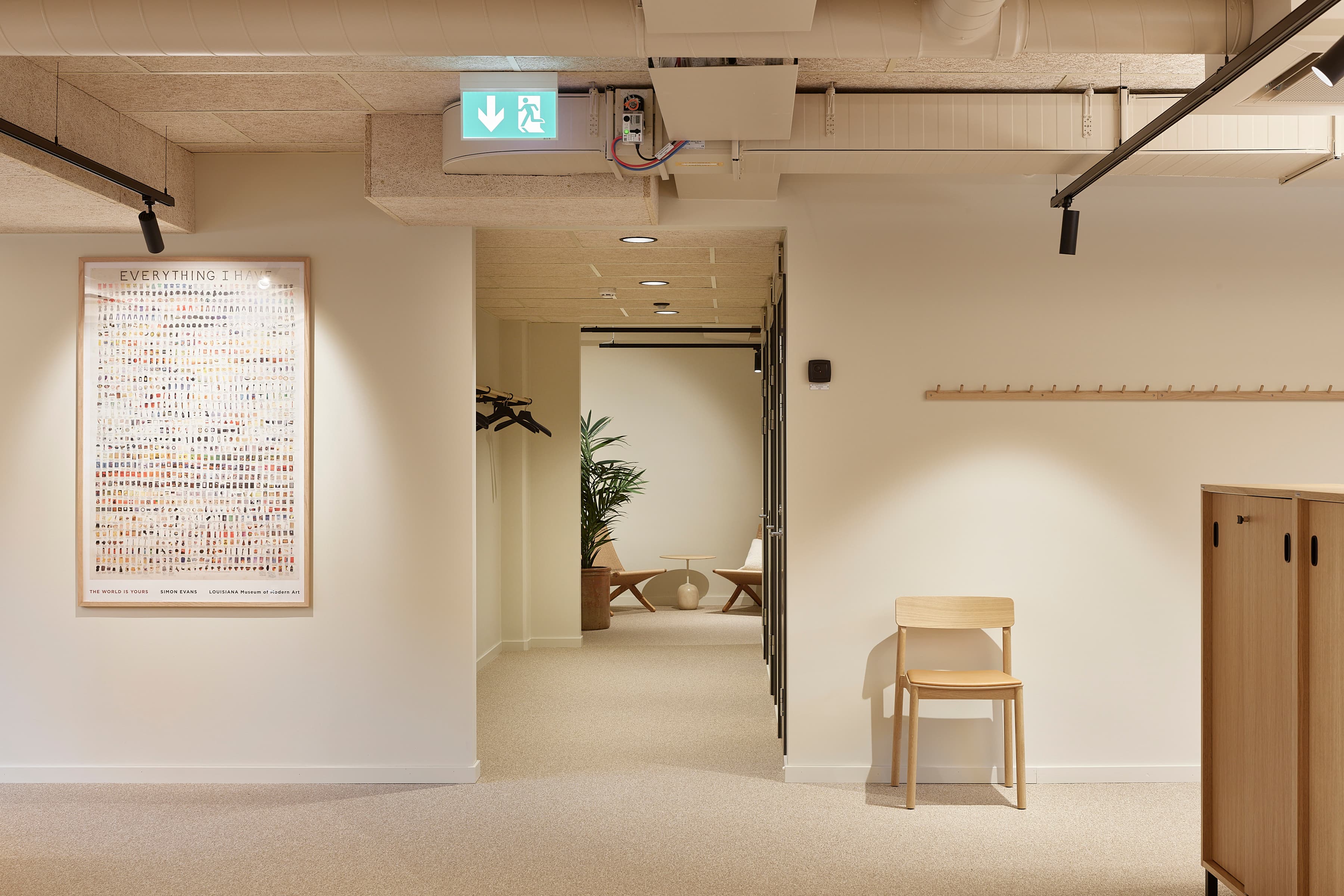 Ett rum med en stol och en klocka på väggen.