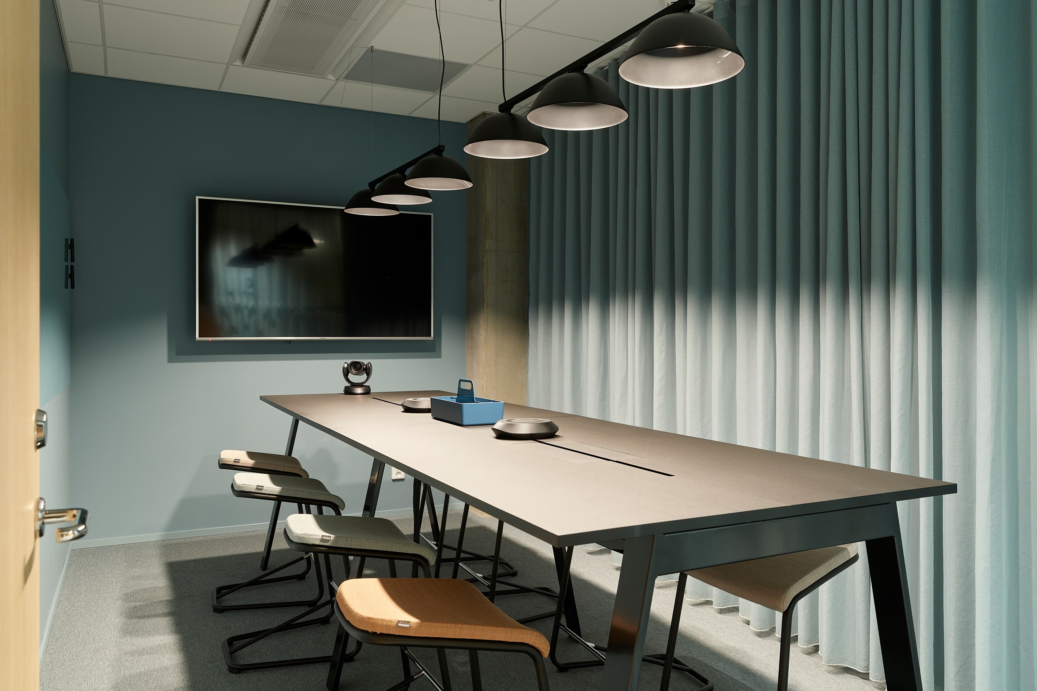 Ett konferensrum med ett långt bord och stolar.