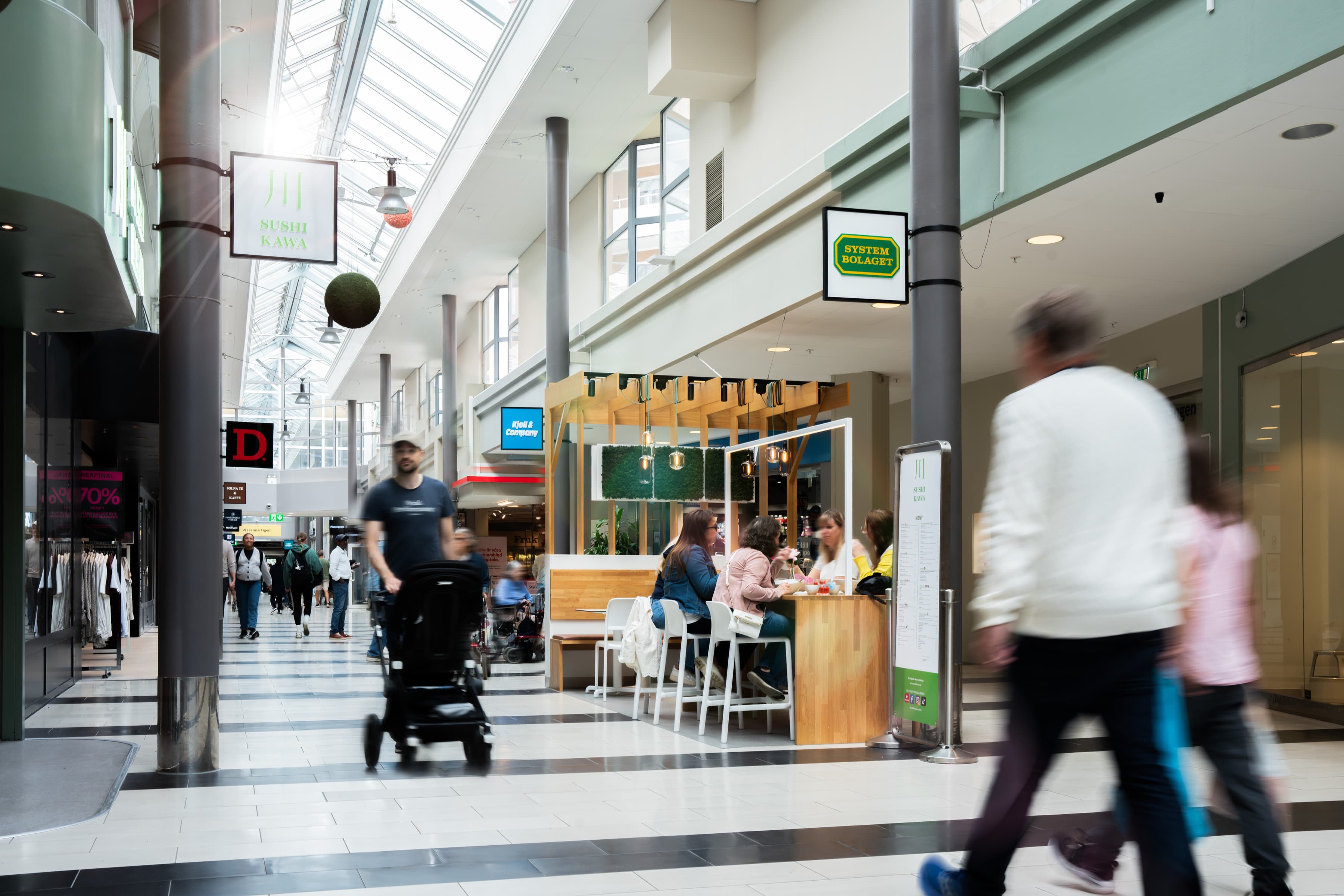 En grupp människor som går genom ett köpcentrum.