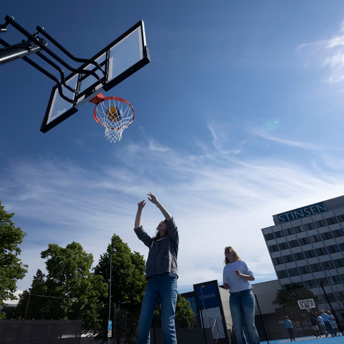 En man och en kvinna som spelar basket på en basketplan.