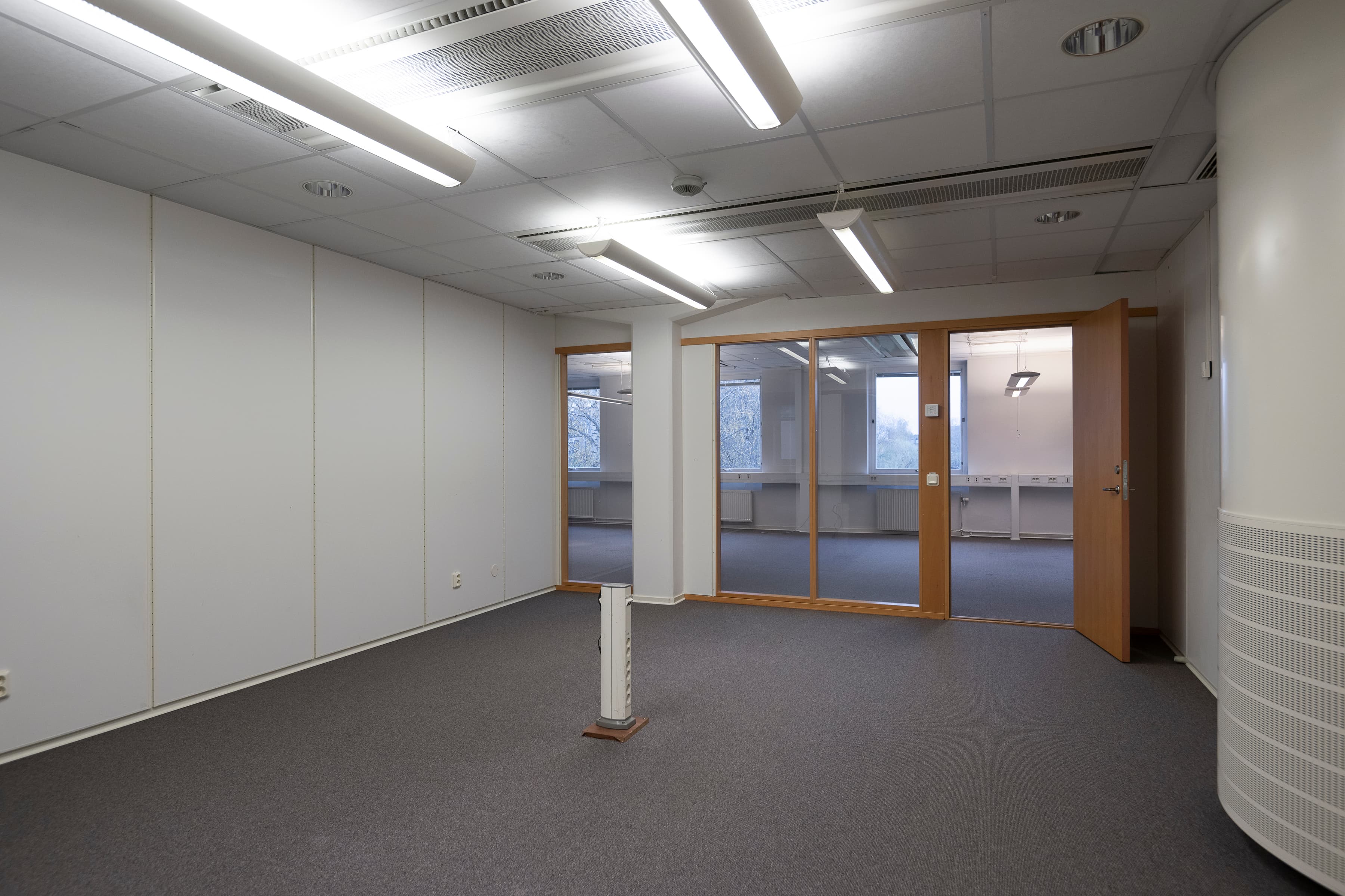 Ett tomt mötesrum med en dörr och ett fönster.