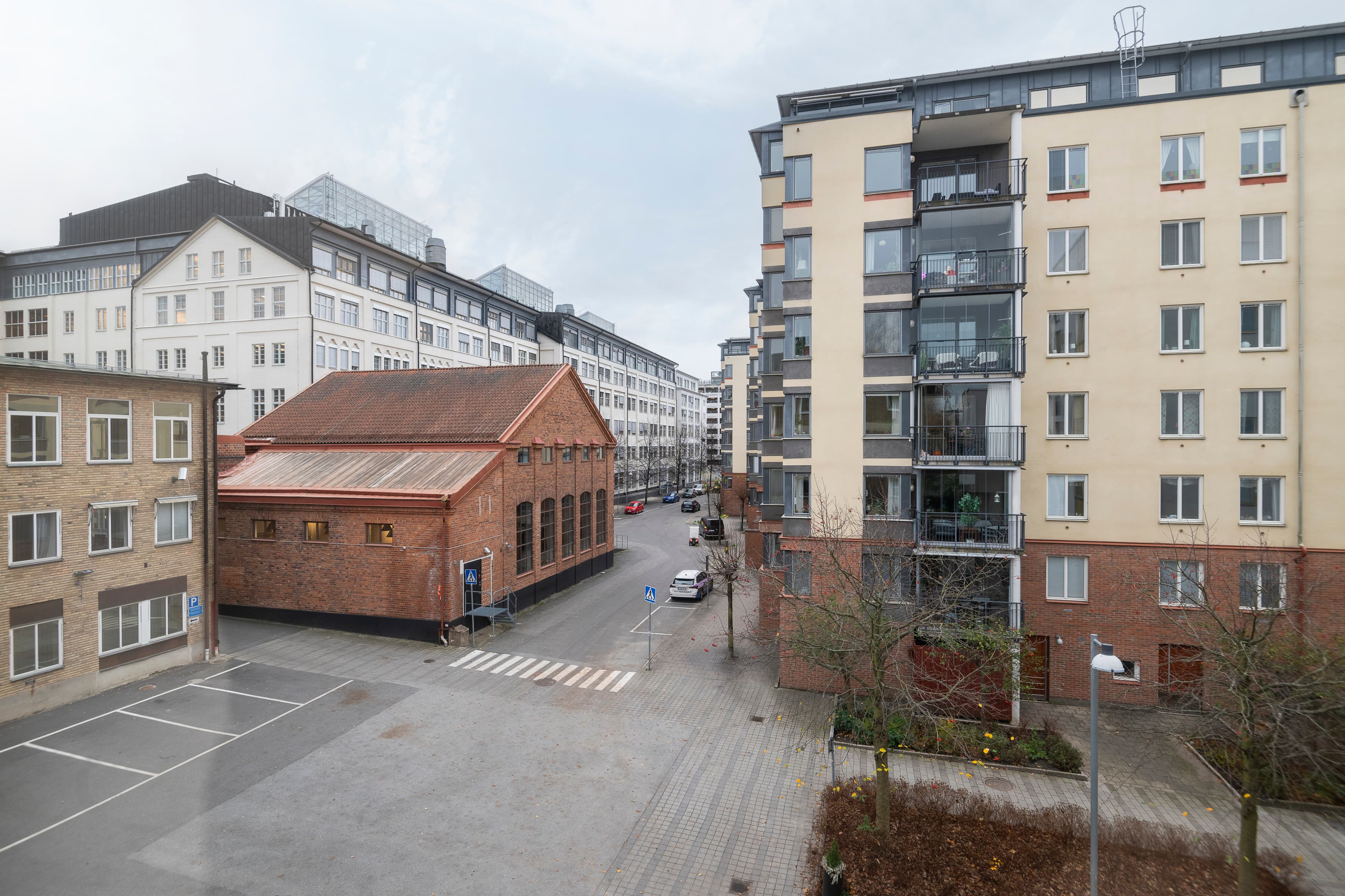 En tom parkeringsplats framför en rad byggnader.