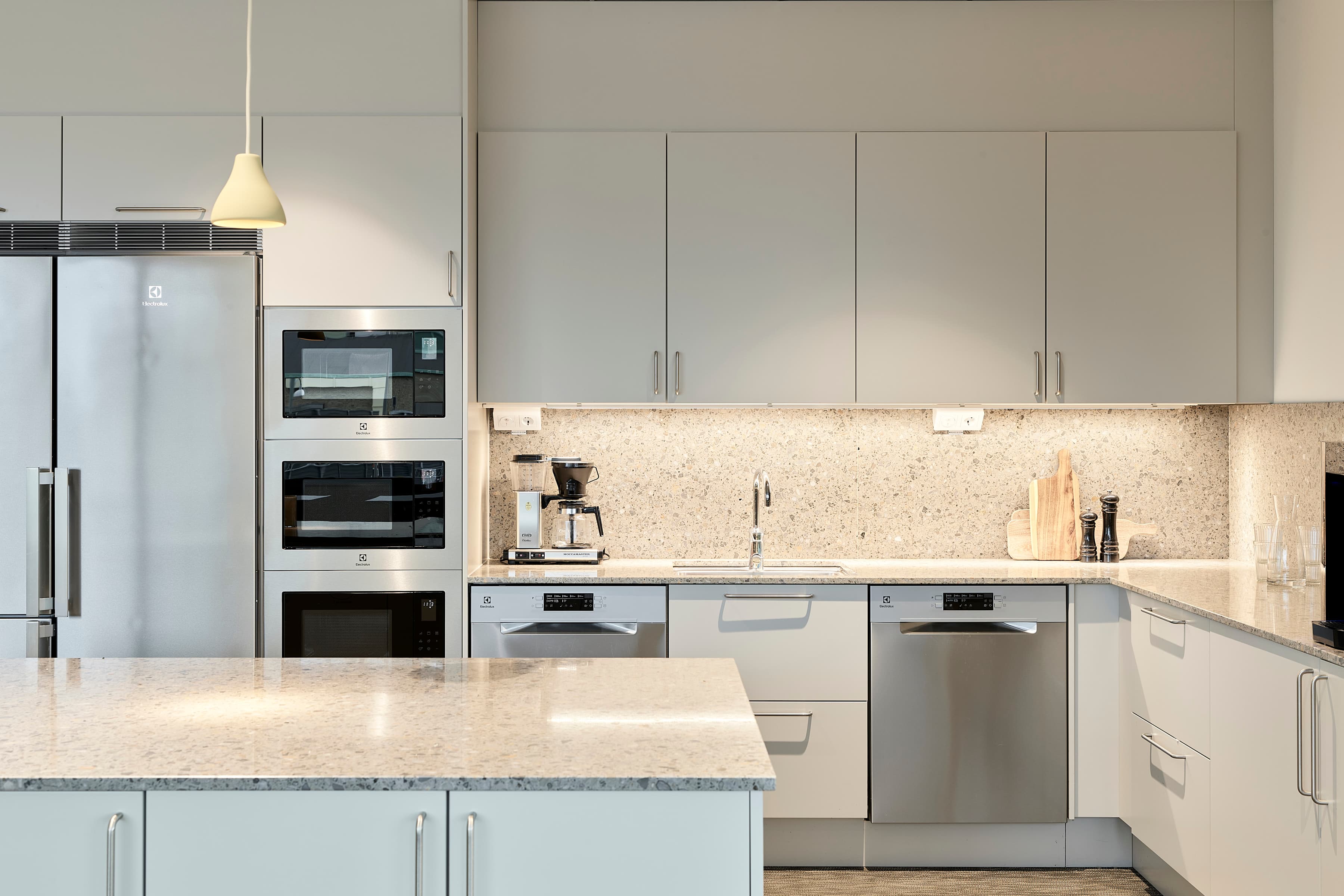 Ett kök med kylskåp, diskho och spis.