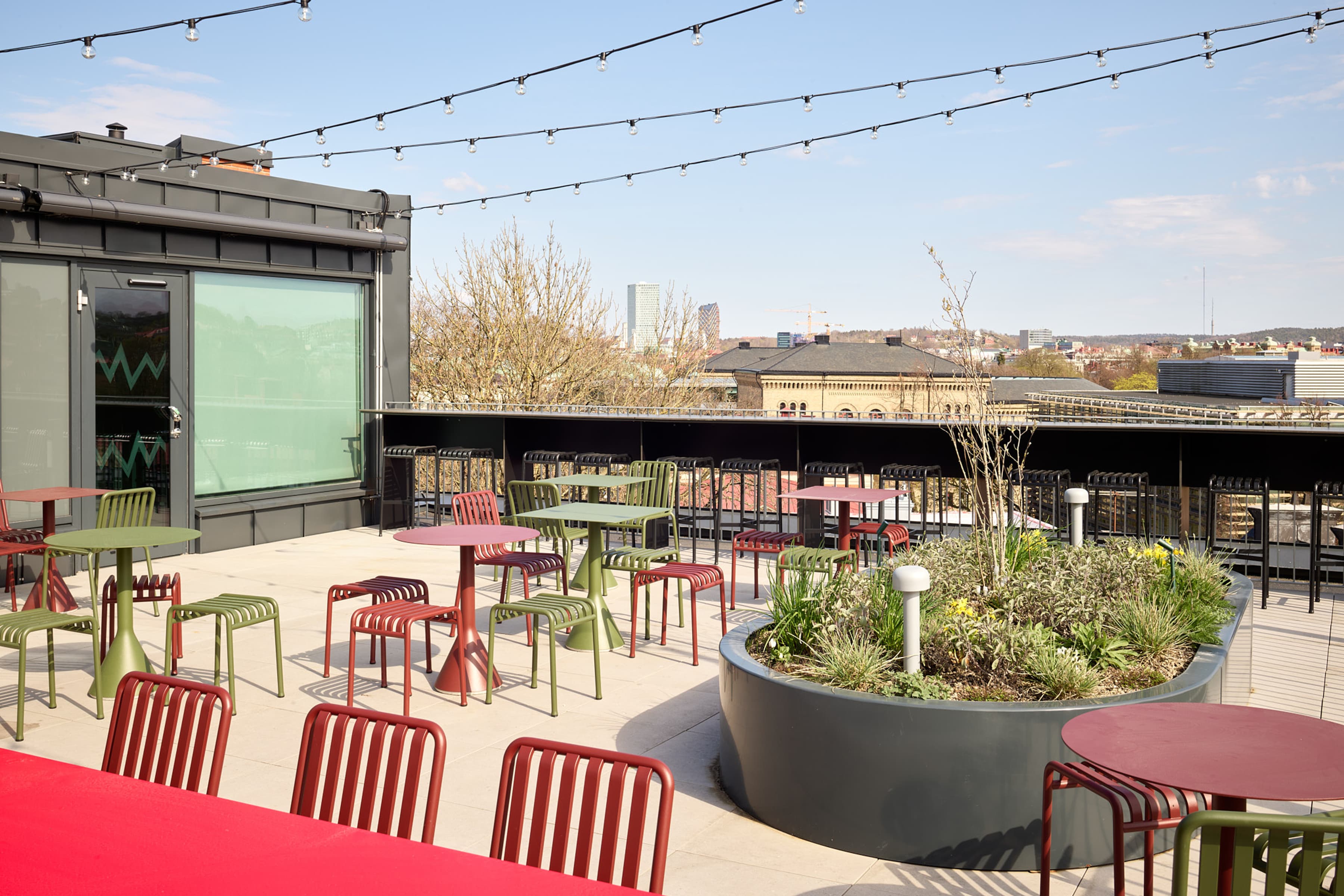 En uteplats med bord och stolar samt ljusslingor.