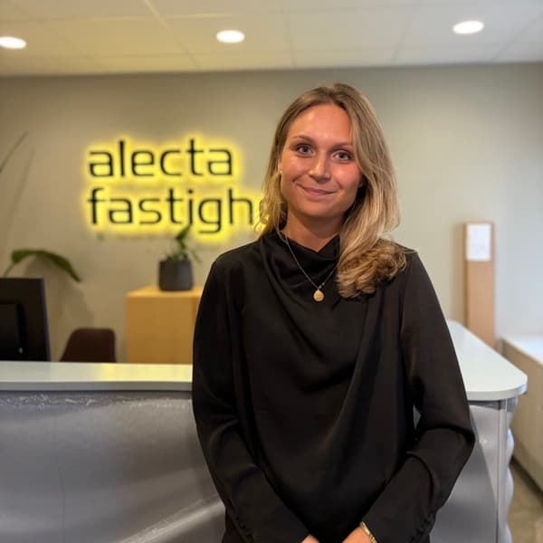 En kvinna står framför en disk på ett kontor.