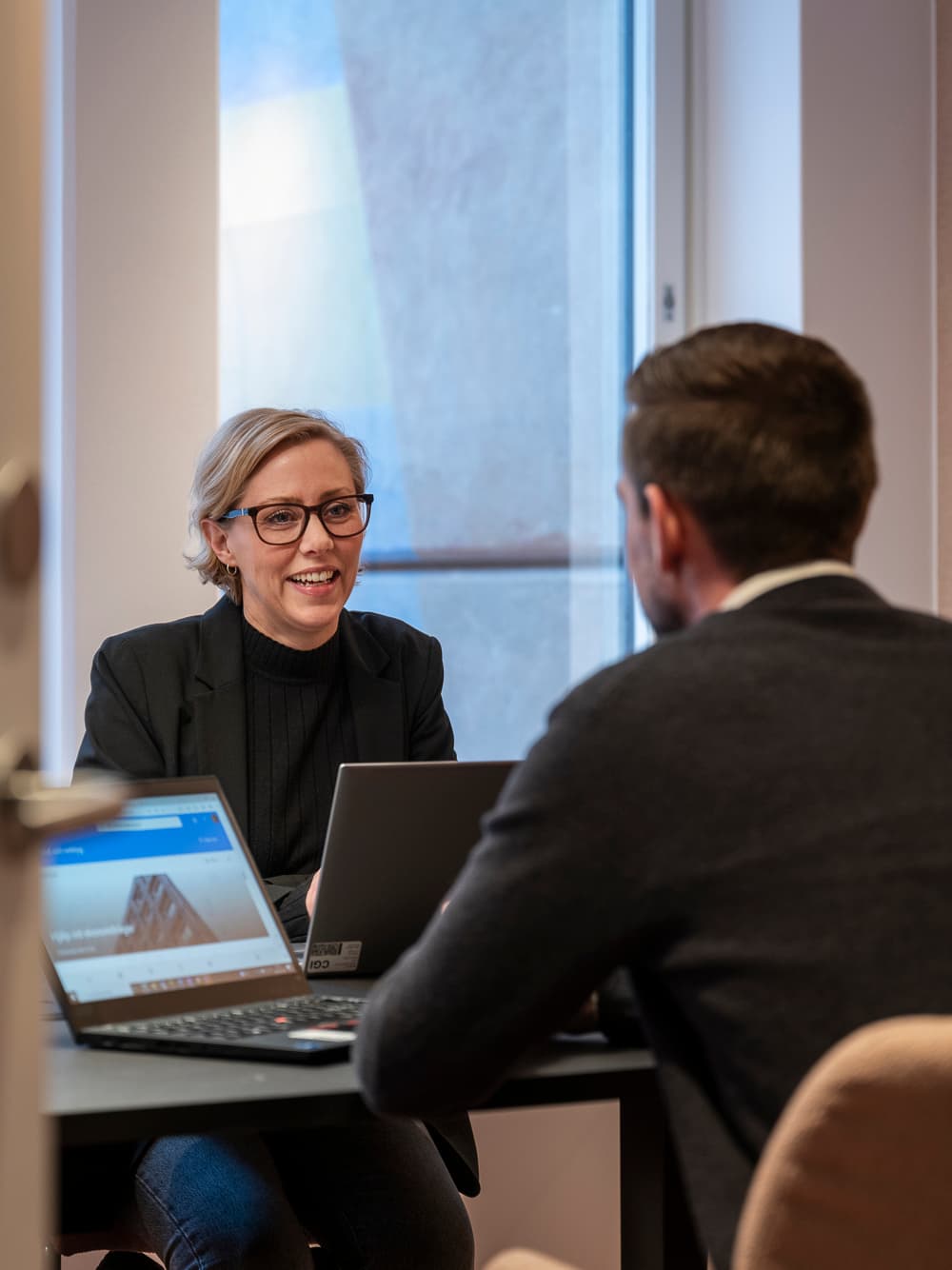 En man och en kvinna sitter vid ett bord med bärbara datorer.
