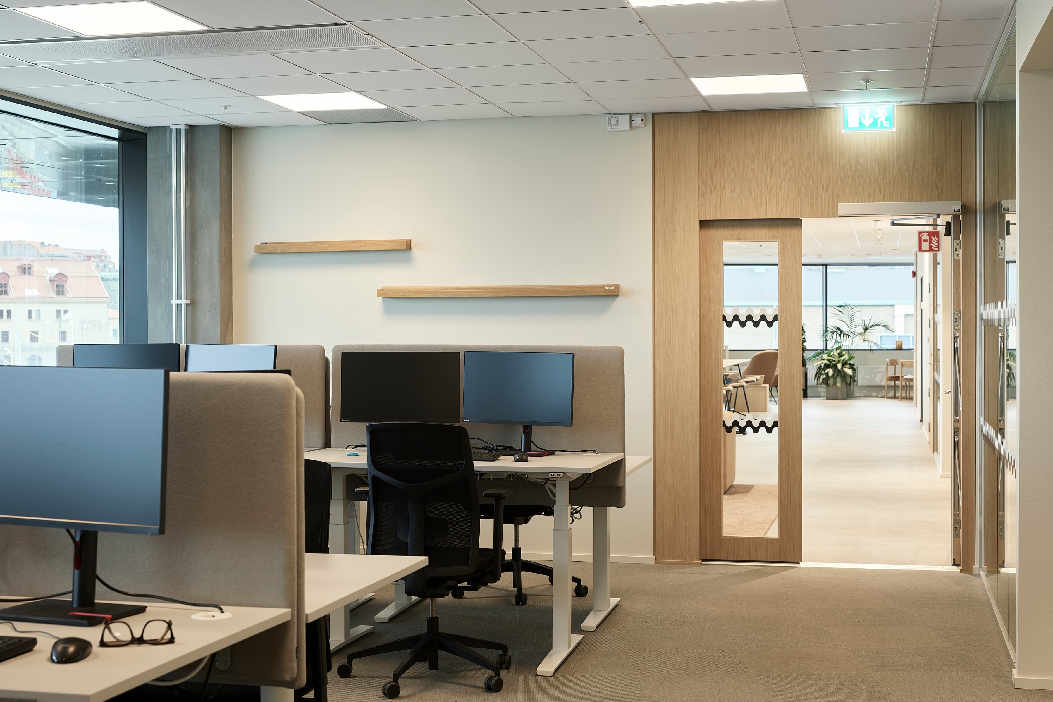 Ett kontor med många skrivbord och datorer.