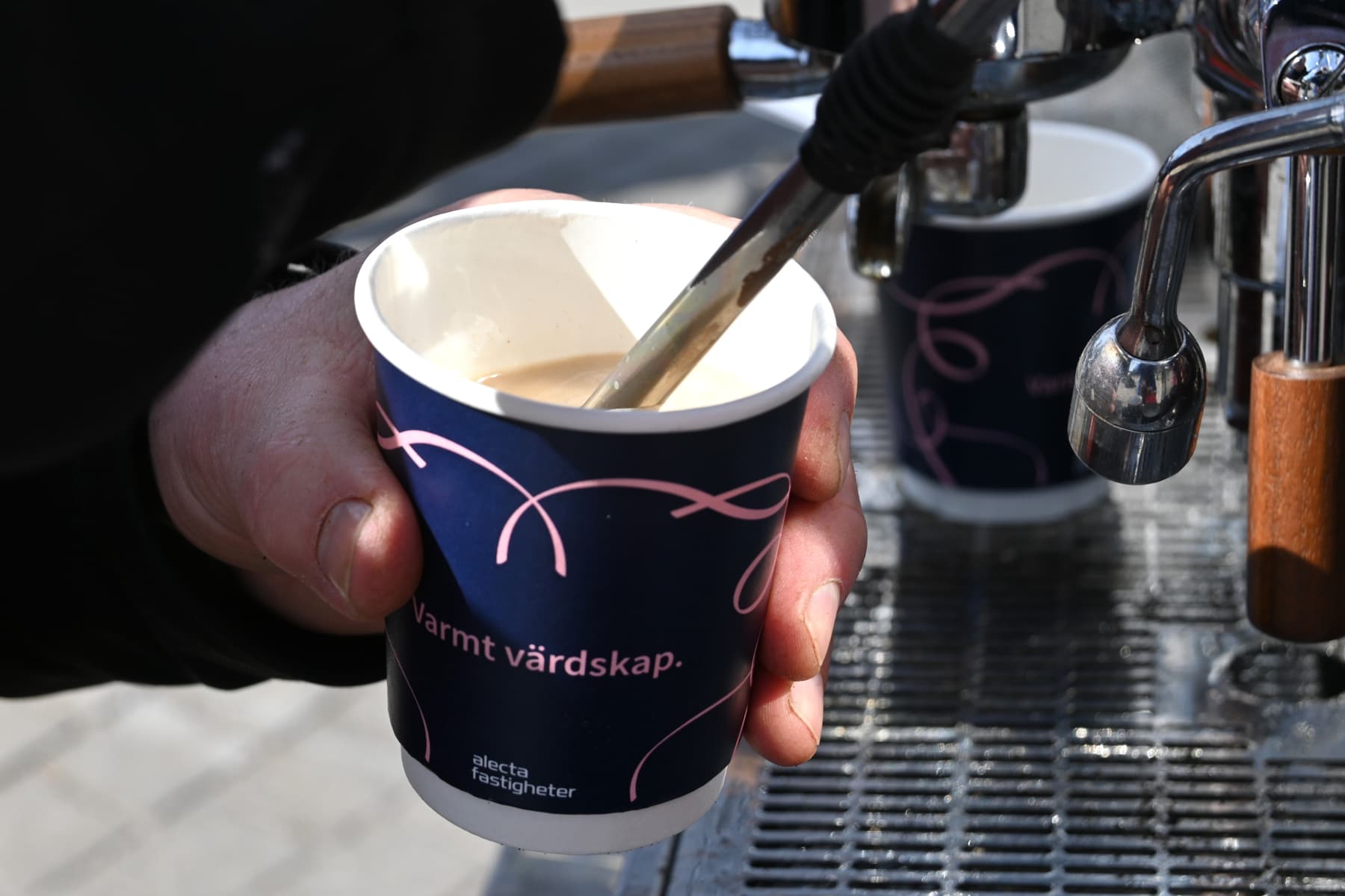 En person håller i en kopp kaffe.