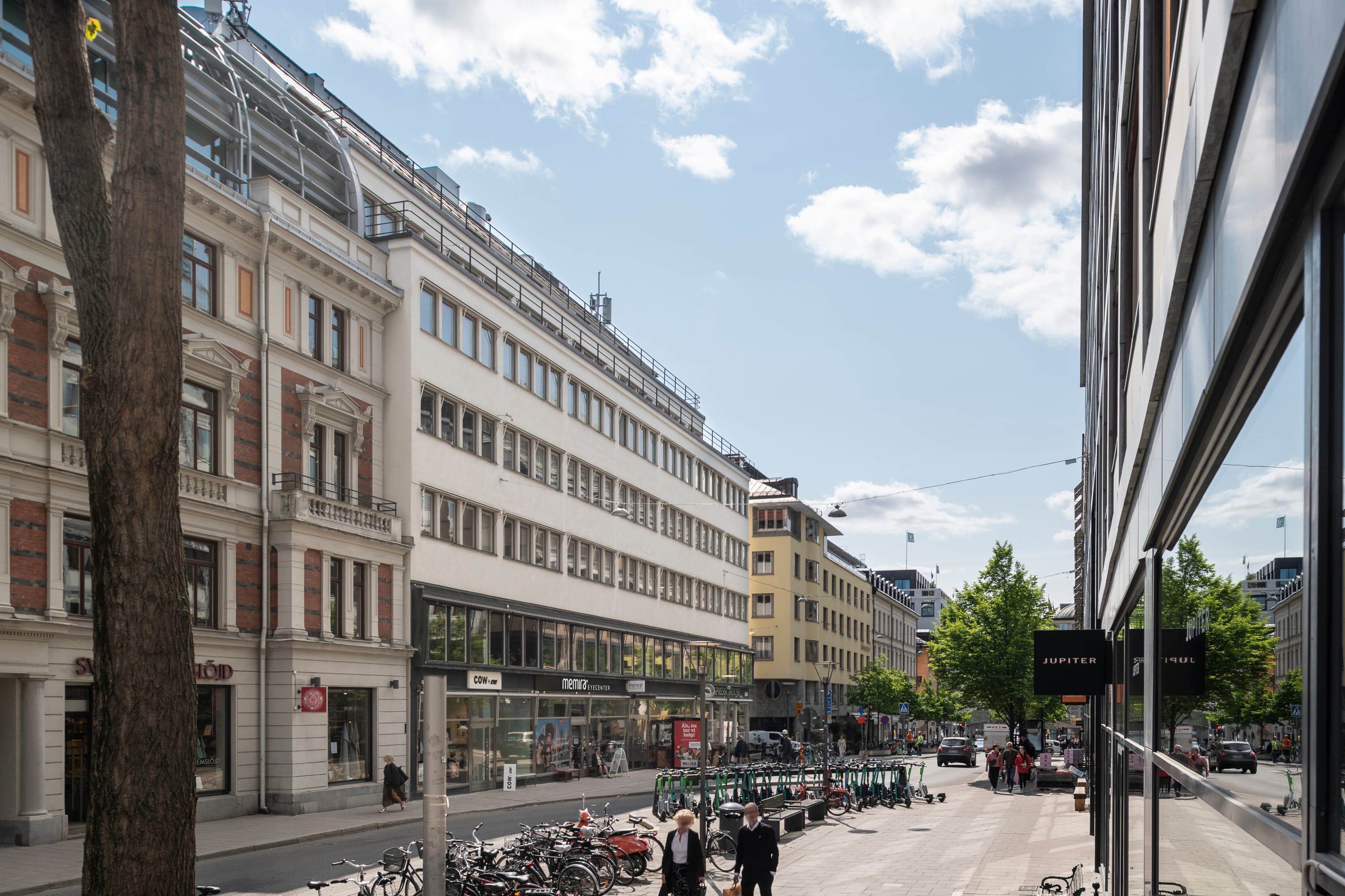 En stadsgata kantad av höga byggnader och parkerade cyklar.