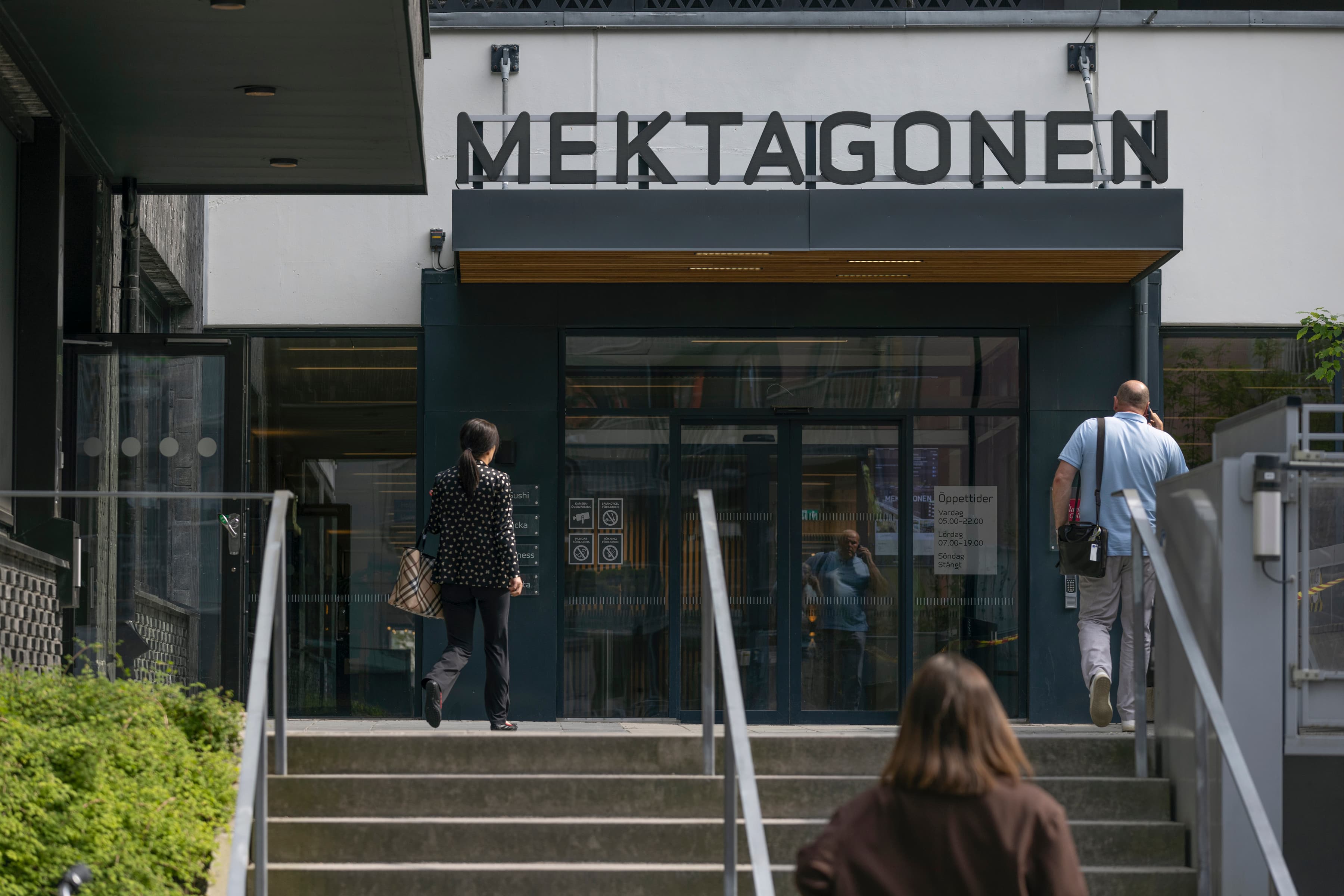 En kvinna går nerför en trappa framför en byggnad.