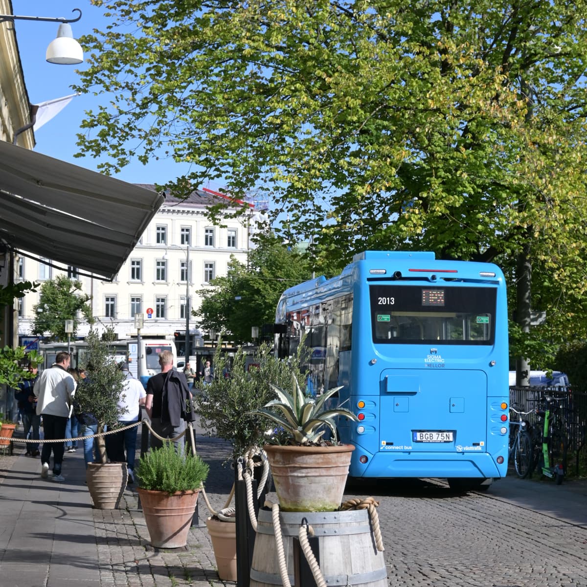 En blå buss parkerad vid sidan av en väg.