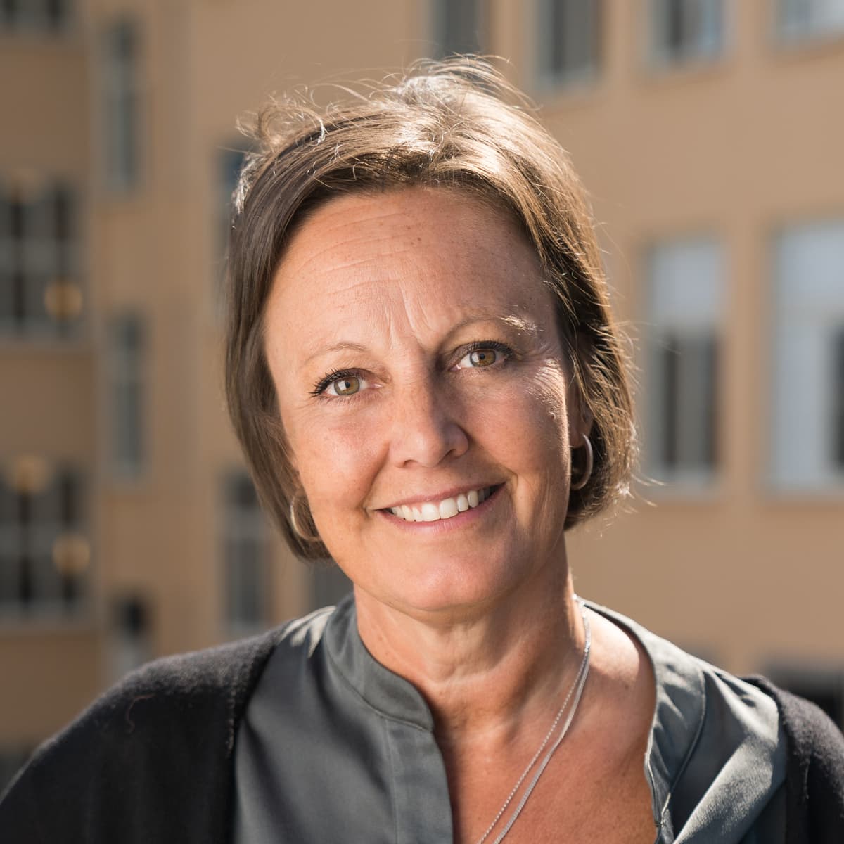 En kvinna som står framför en hög byggnad.