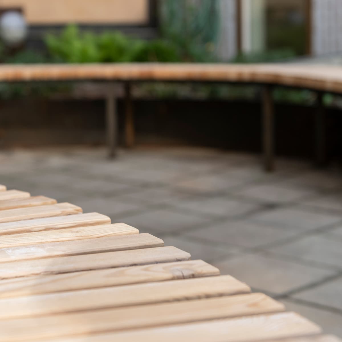 En närbild av en träbänk på en uteplats.