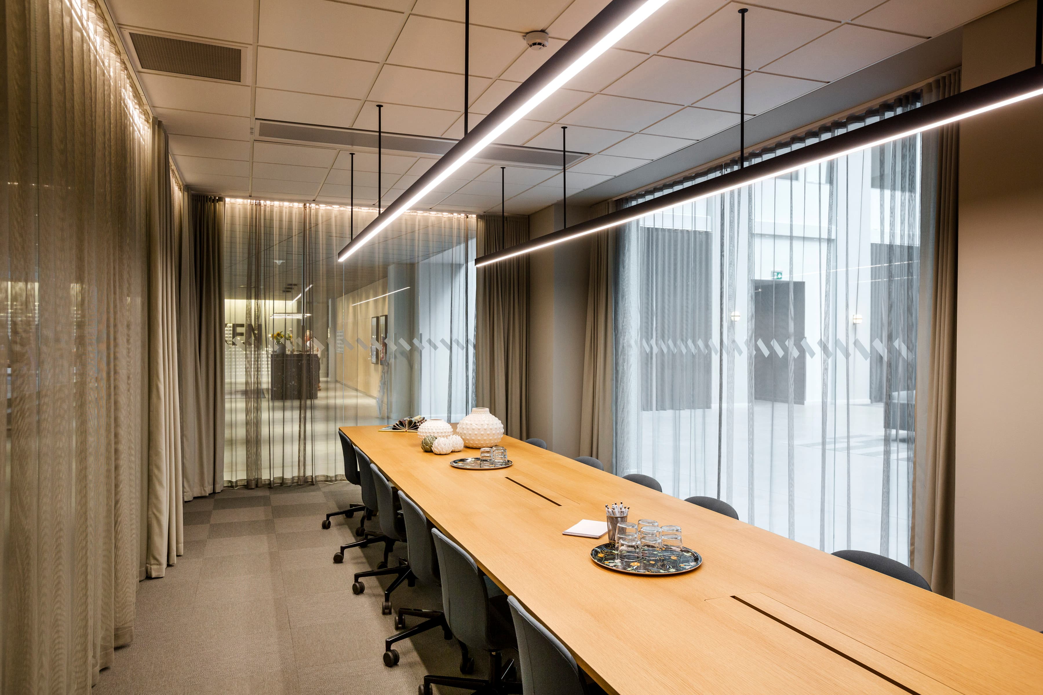 Ett konferensrum med ett långt bord och stolar.