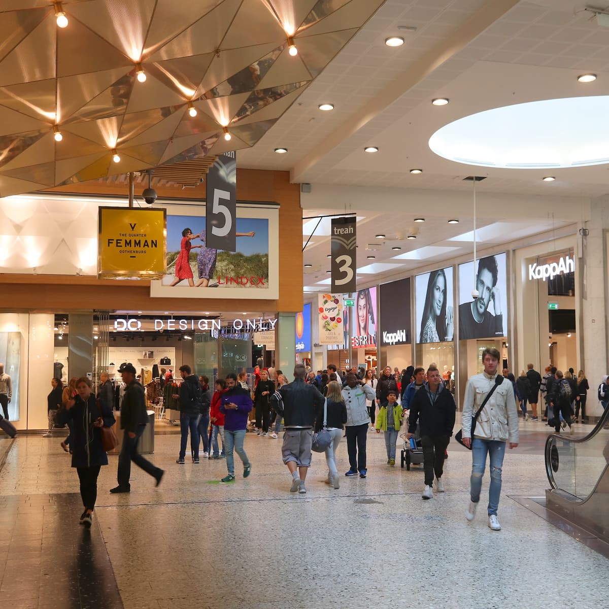 En grupp människor som går genom ett köpcentrum.