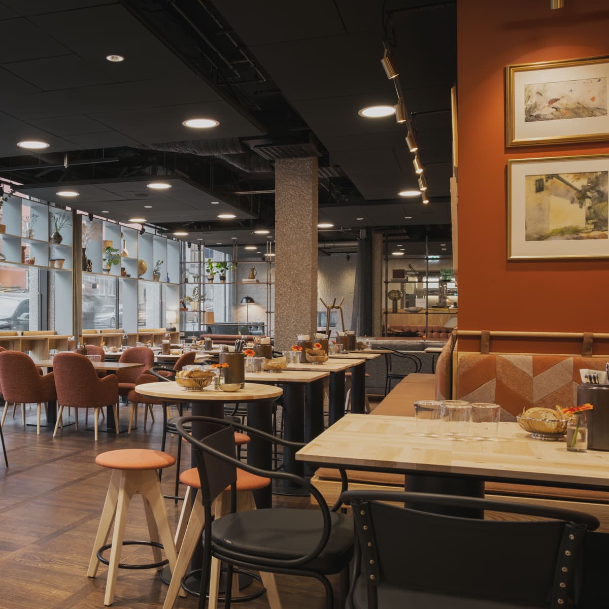 En restaurang fylld med många bord och stolar.