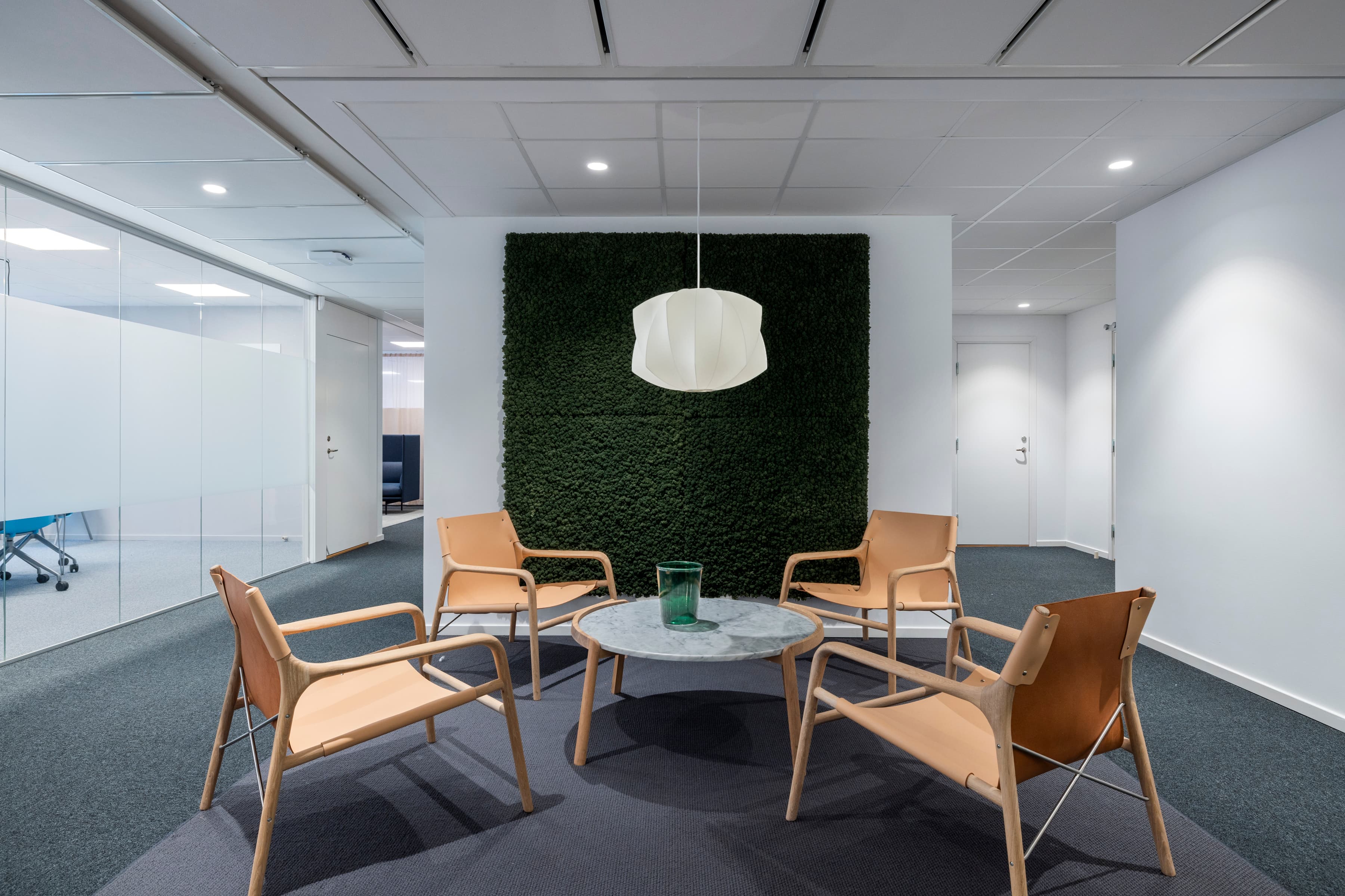 Ett rum med stolar, ett bord och en grön vägg.