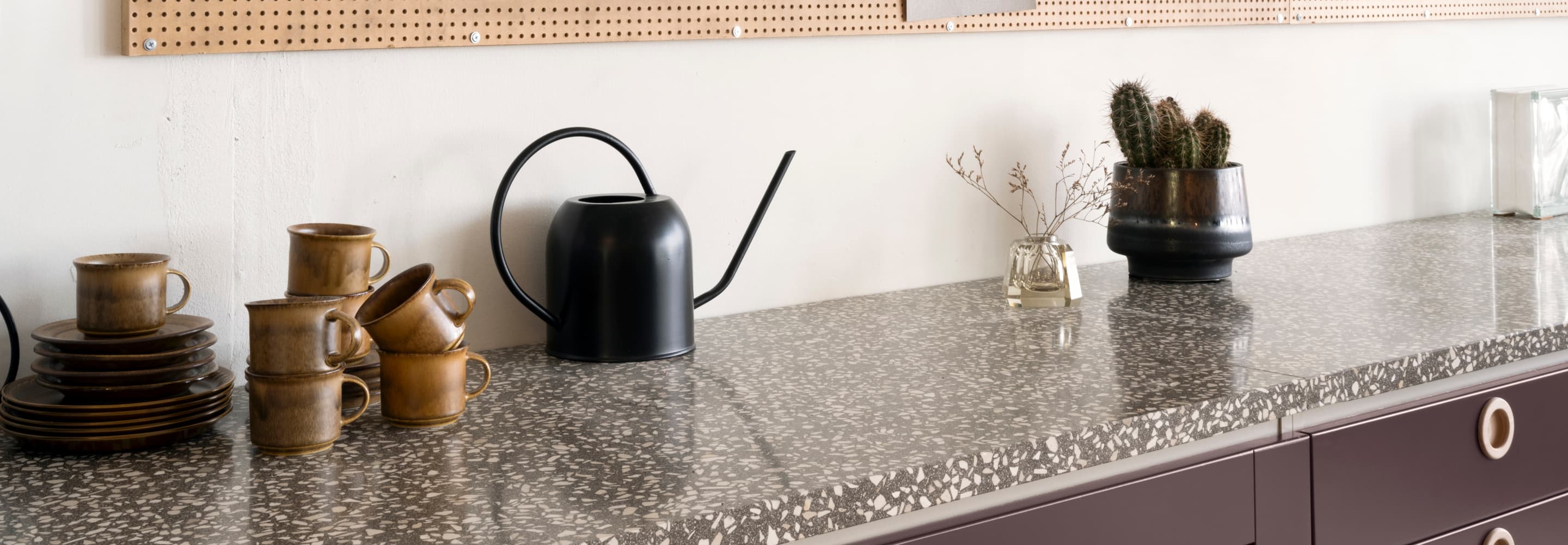 Ett kök med en bänkskiva och en väggmonterad pegboard.