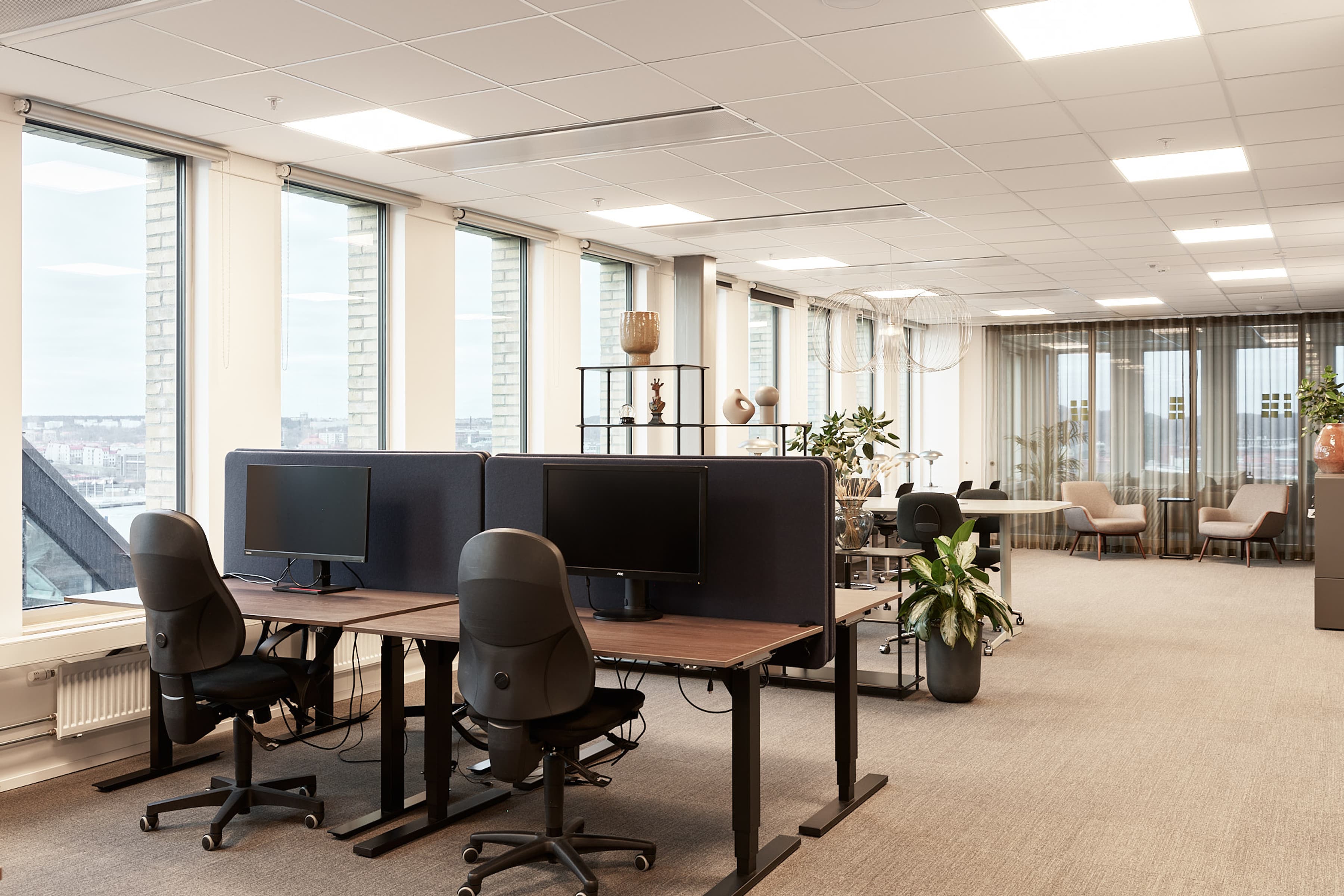 Ett tomt kontor med två skrivbord och ett stort fönster.
