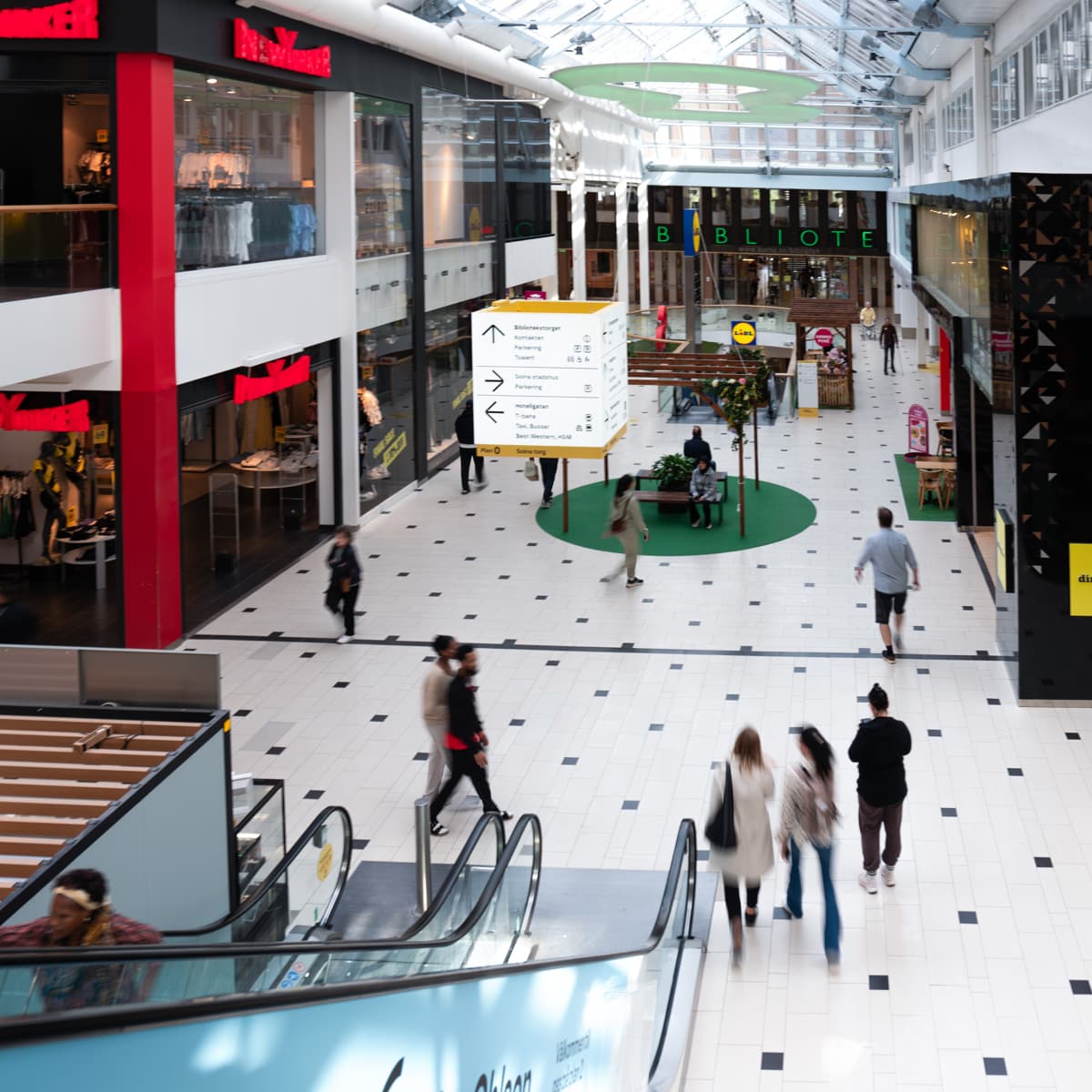 En grupp människor som går genom ett köpcentrum.