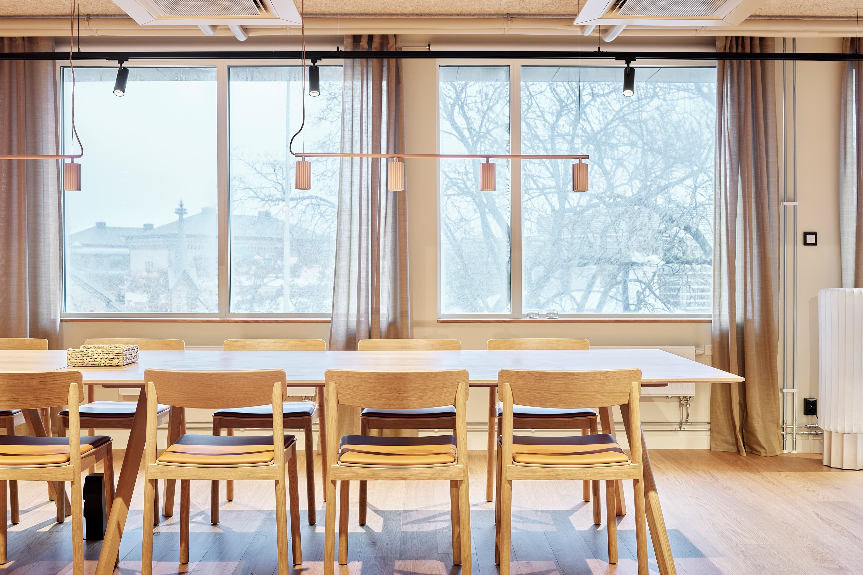 Ett bord och stolar i ett rum med stora fönster.