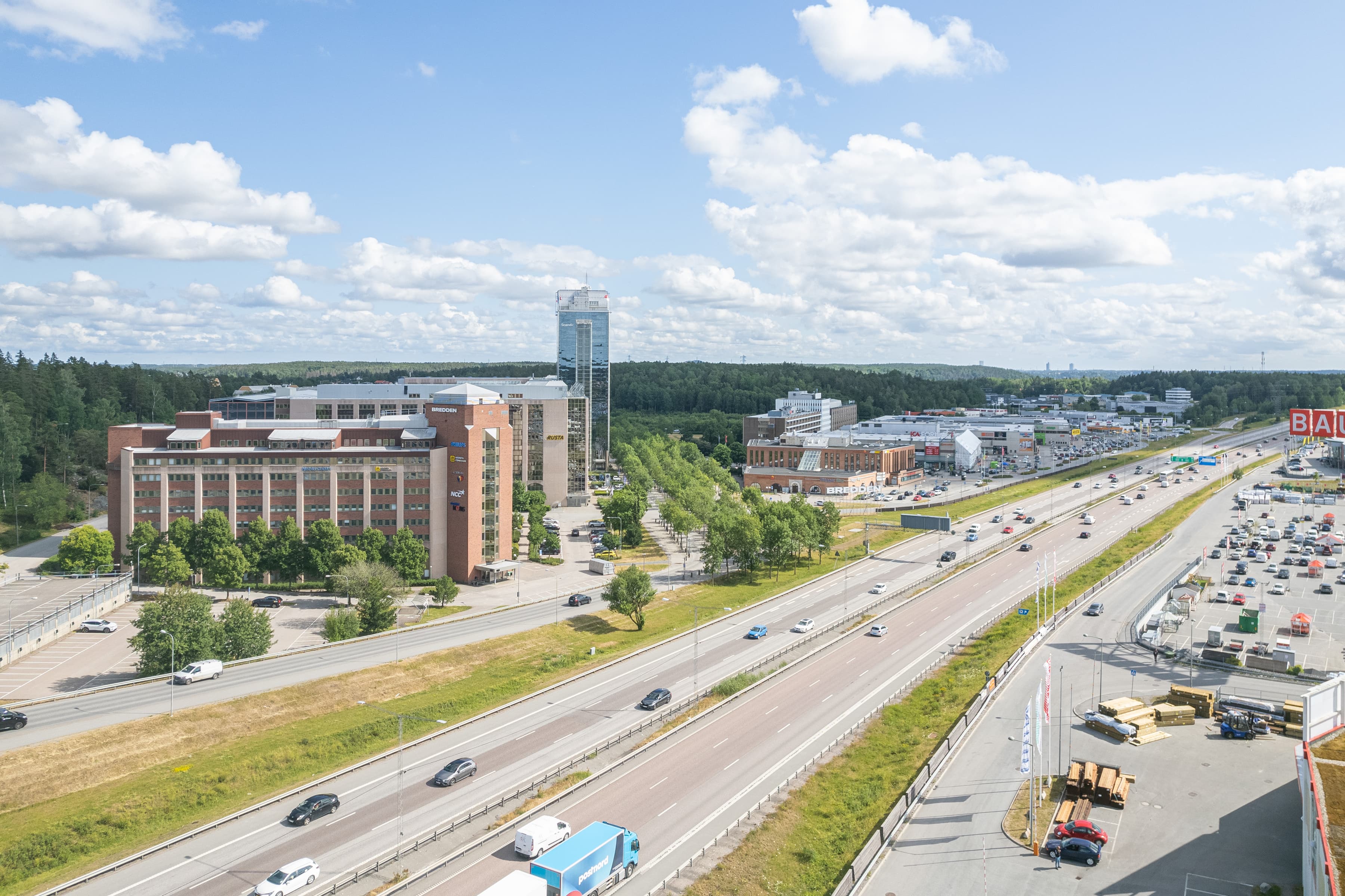 En flygbild av en motorväg med en stor byggnad i bakgrunden.