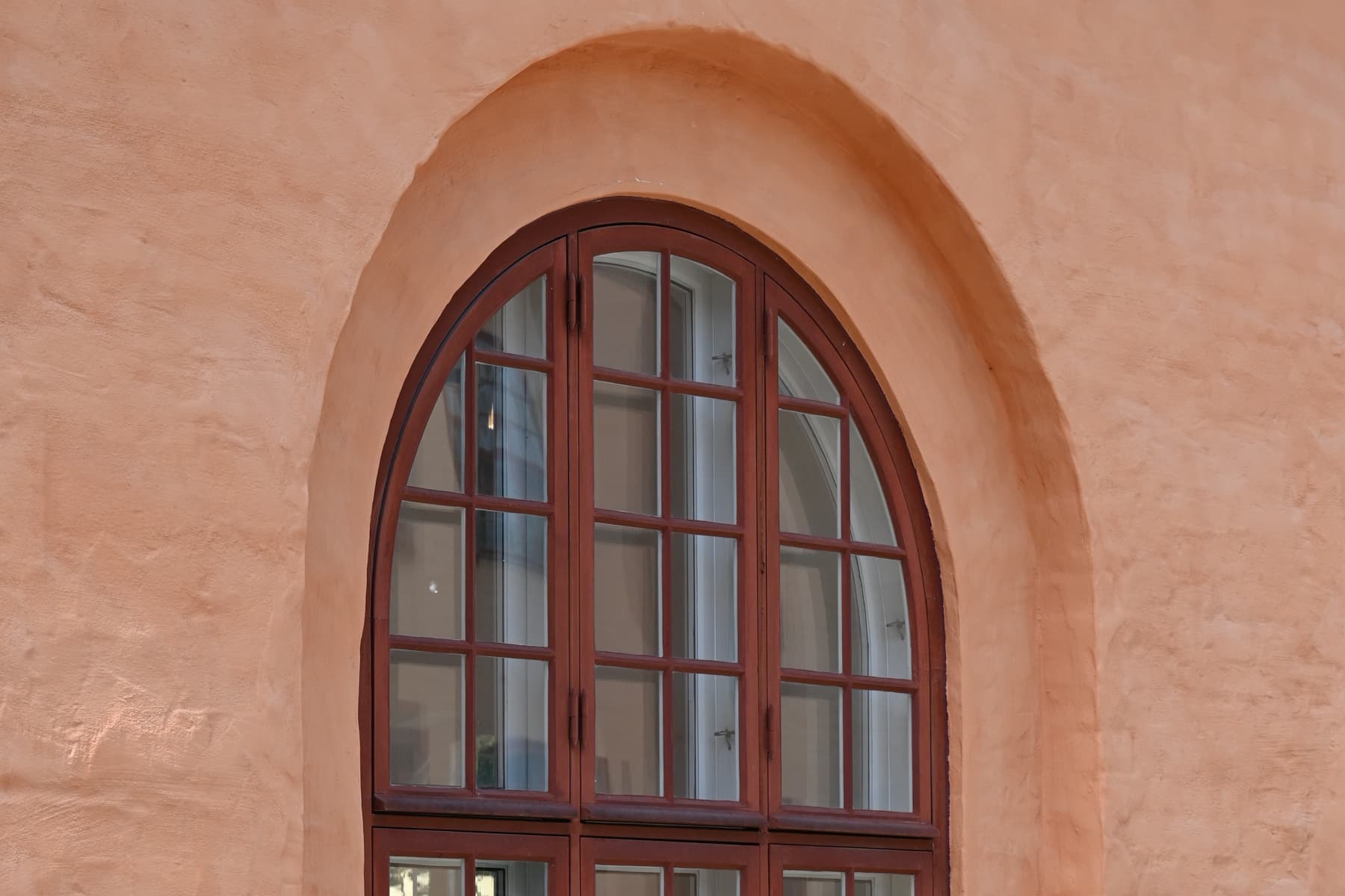 En katt som sitter på en fönsterbräda framför en byggnad.