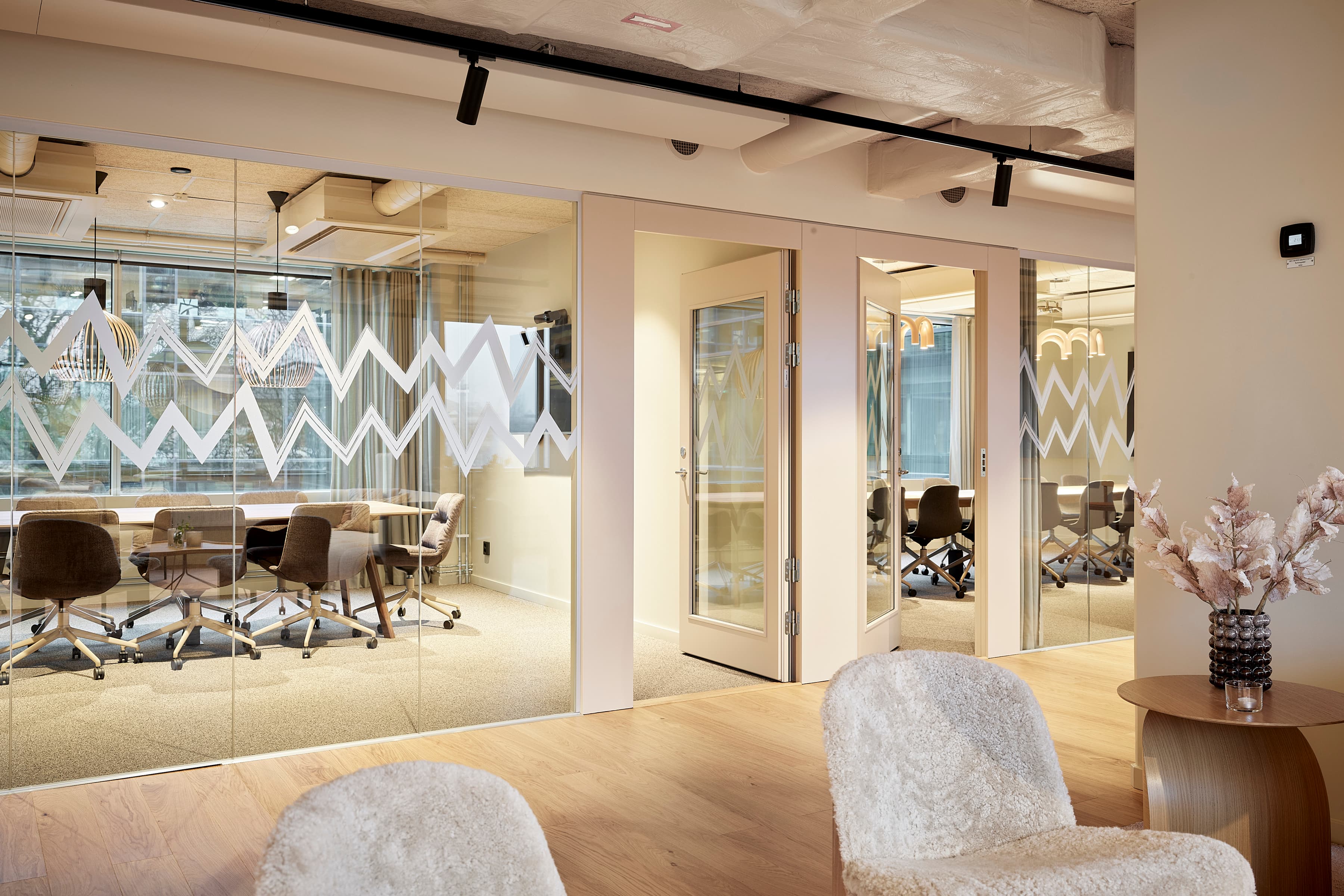 Ett rum med stolar, ett bord och en glasvägg.