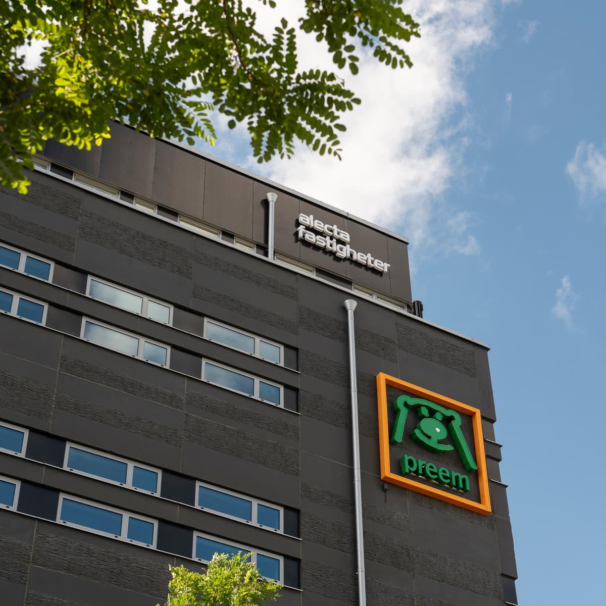 En byggnad med en grön och orange skylt på.