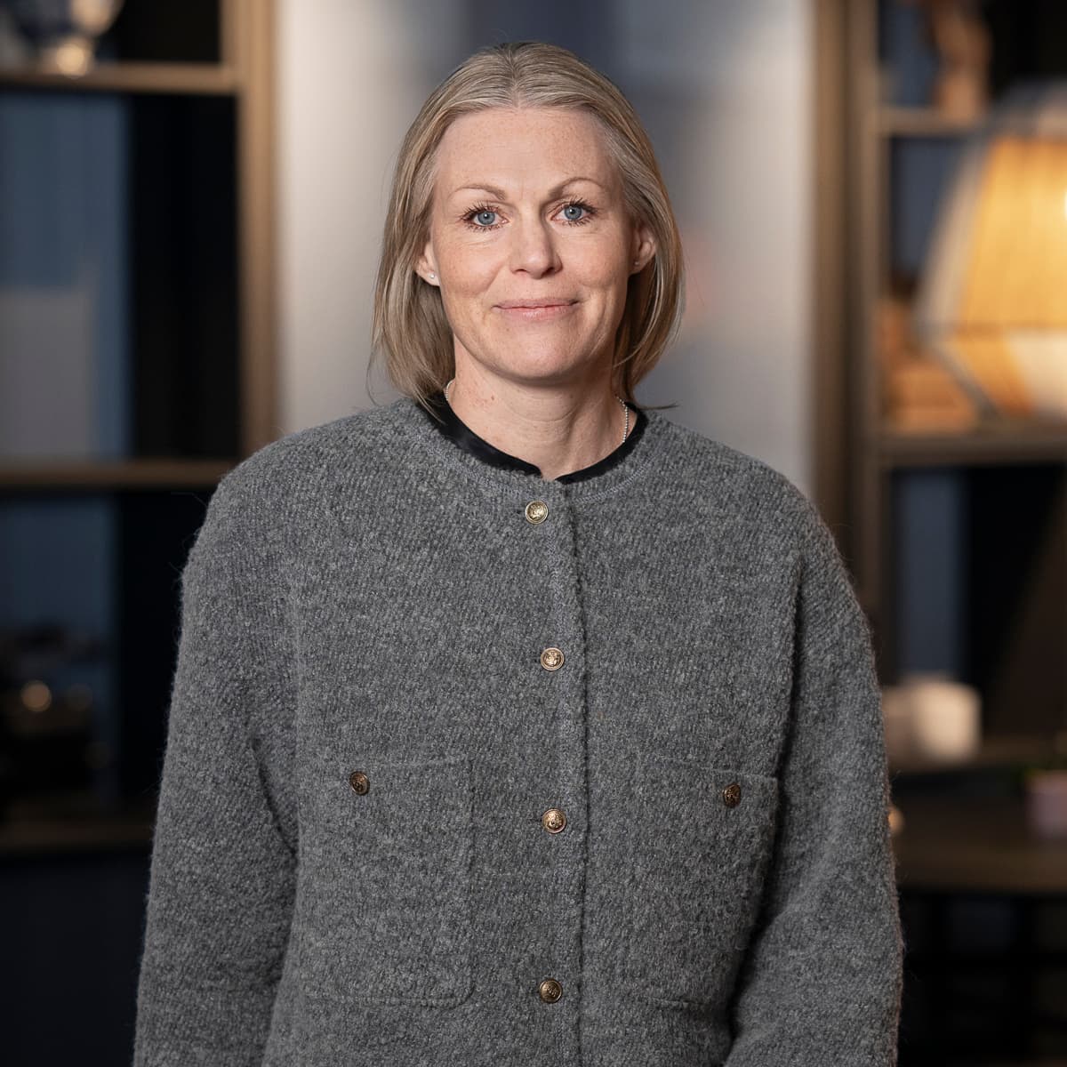 En kvinna står framför ett bord i ett rum.