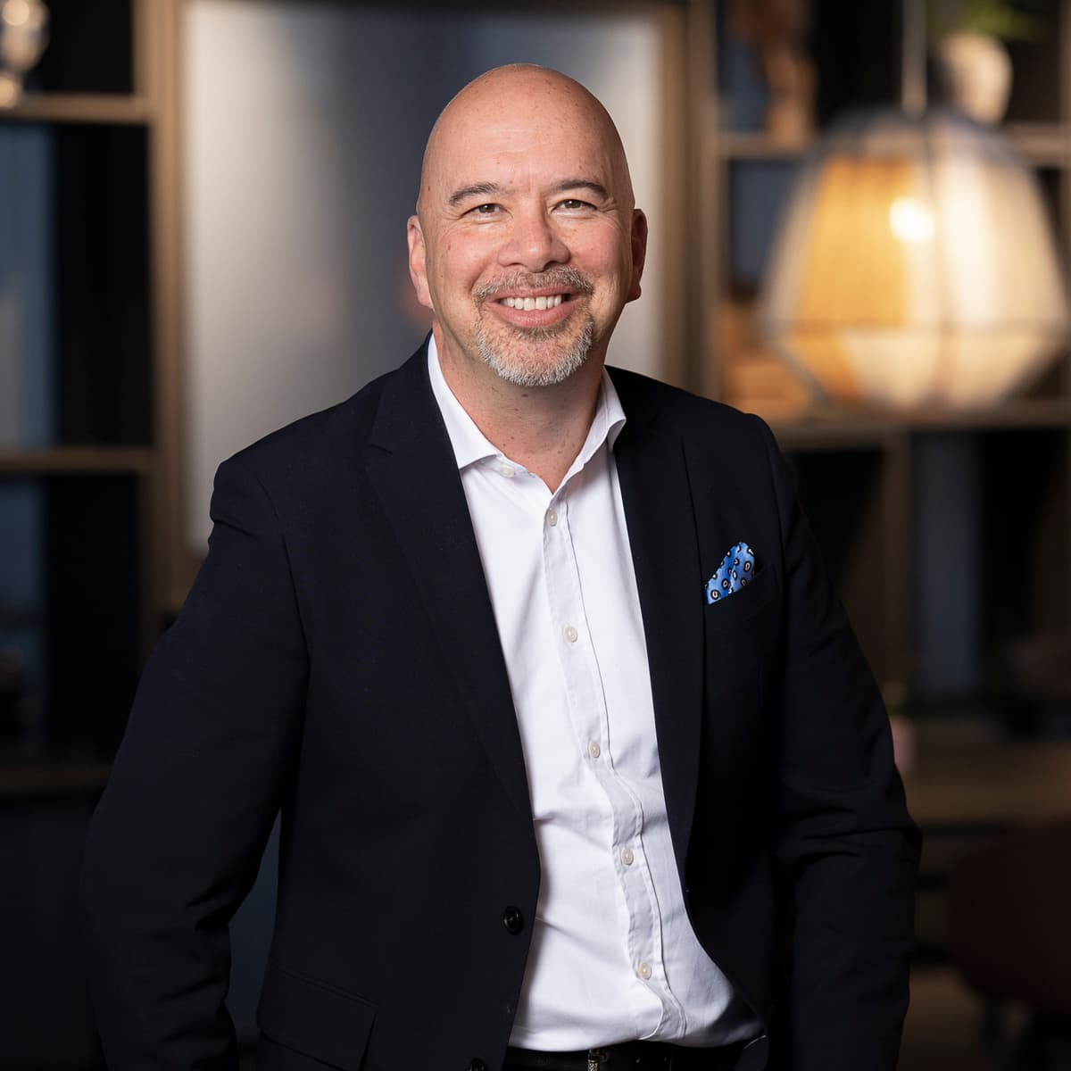 En kostymklädd man står i ett rum.