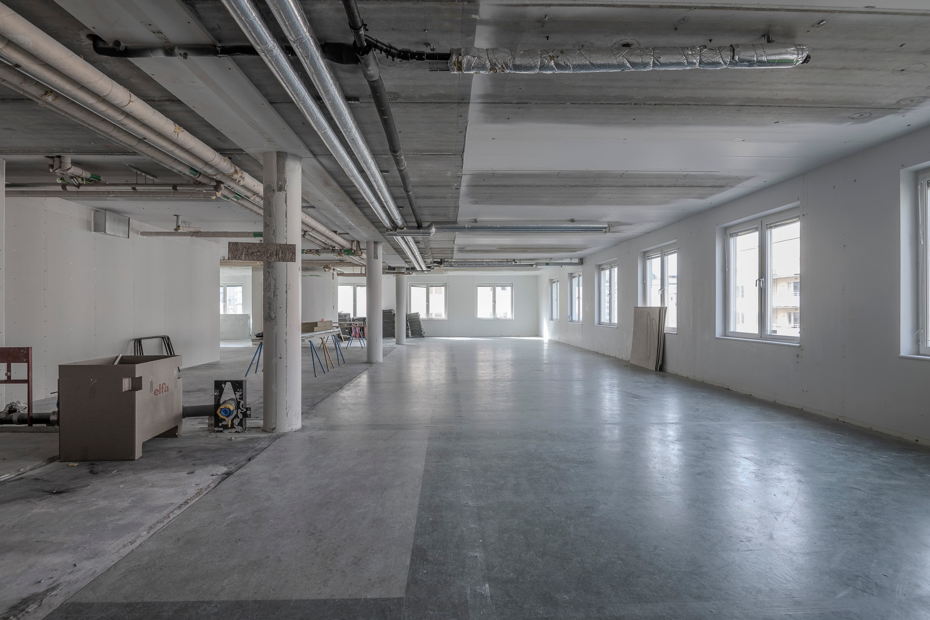 Ett stort tomt rum med många fönster.