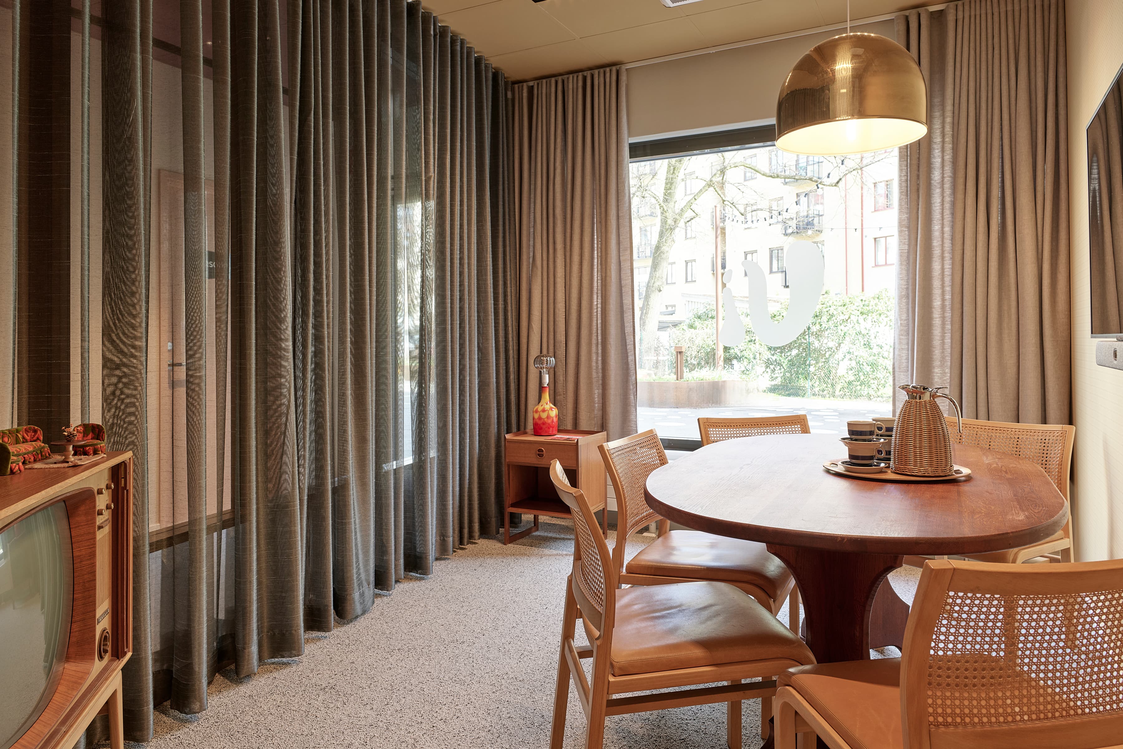 Ett rum med bord, stolar och TV.