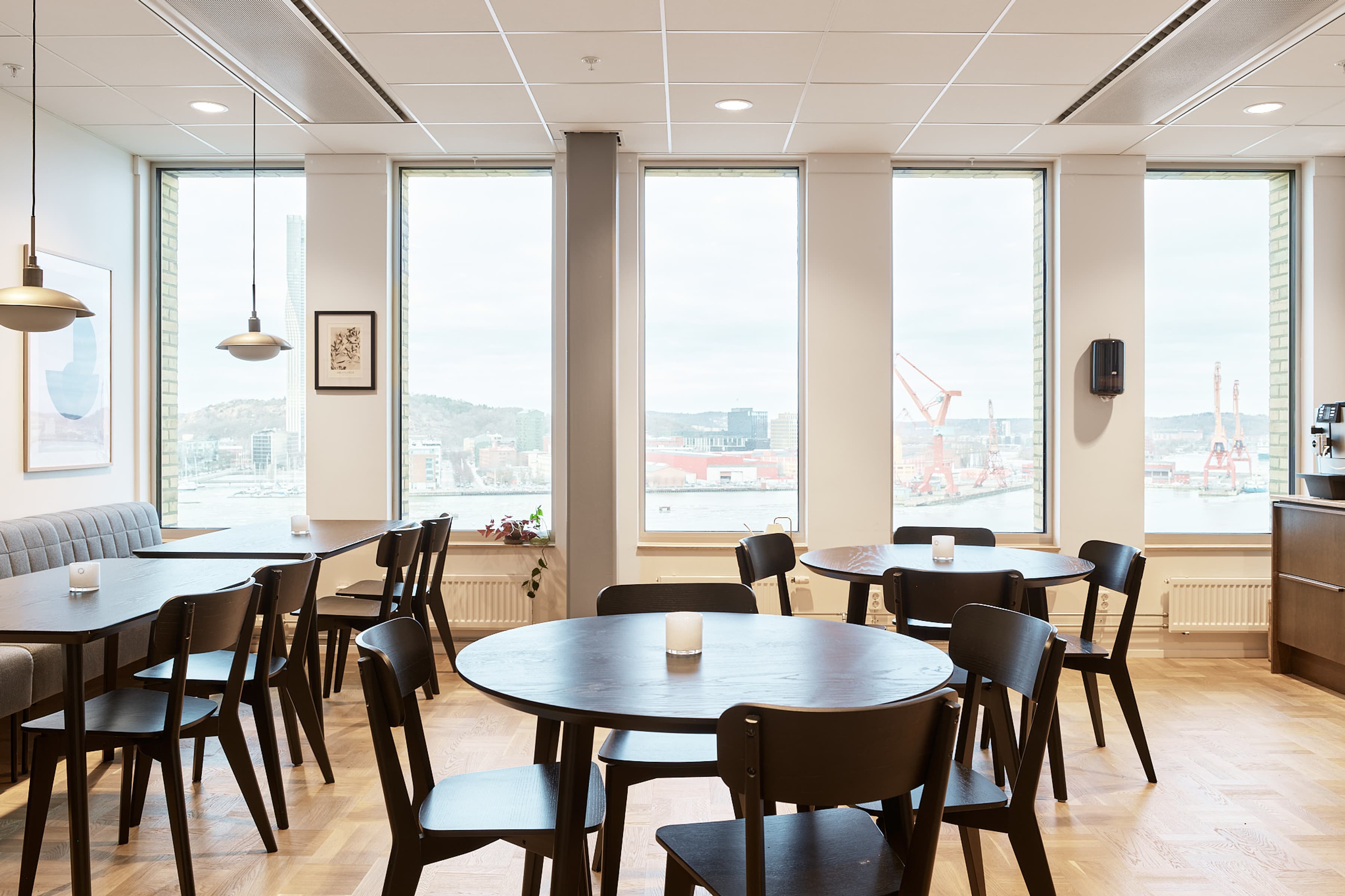 En restaurang med bord och stolar och utsikt över en stad.