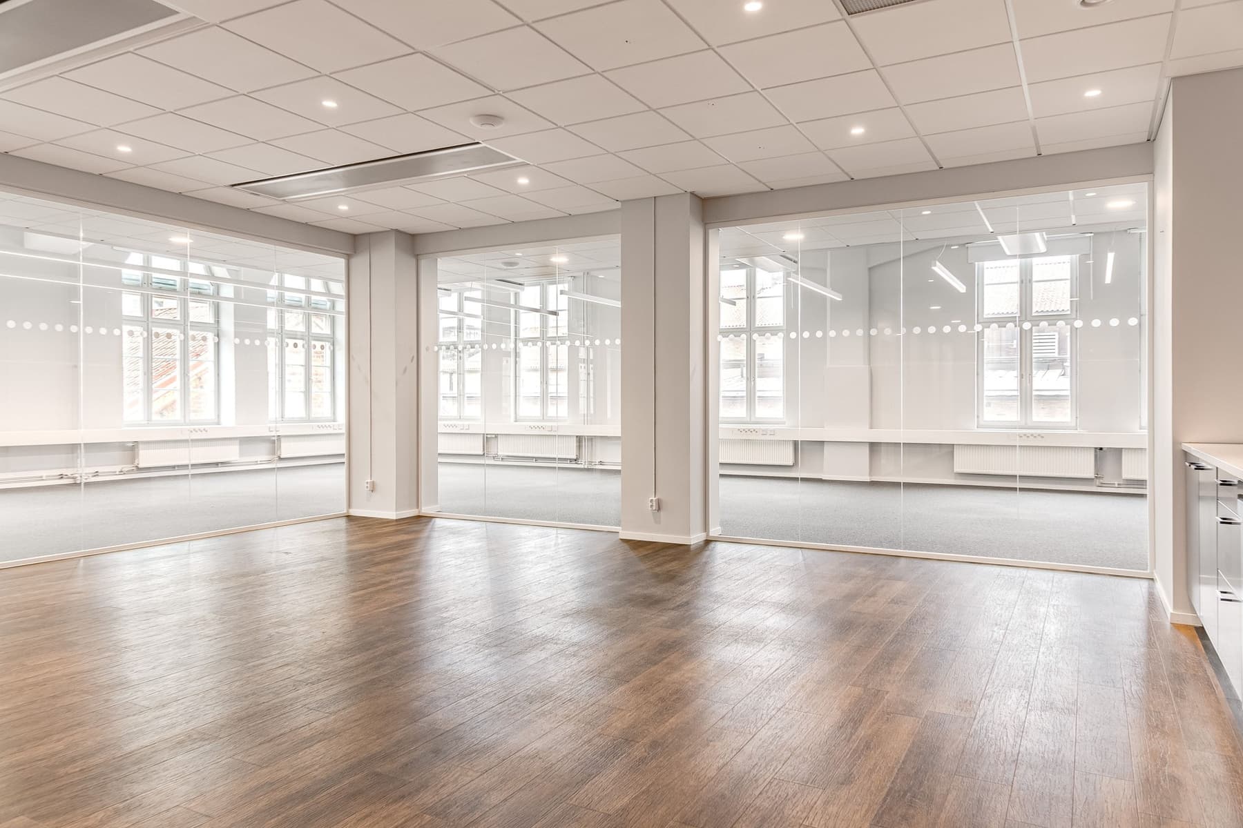 Ett tomt rum med vita väggar och trägolv.