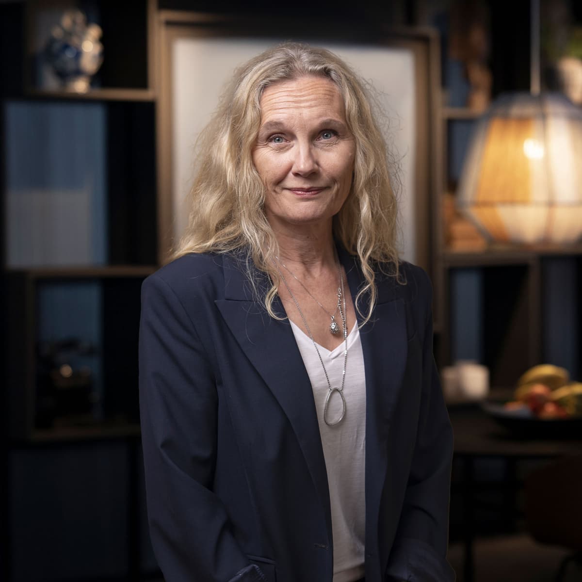 En kvinna står framför ett bord i ett rum.